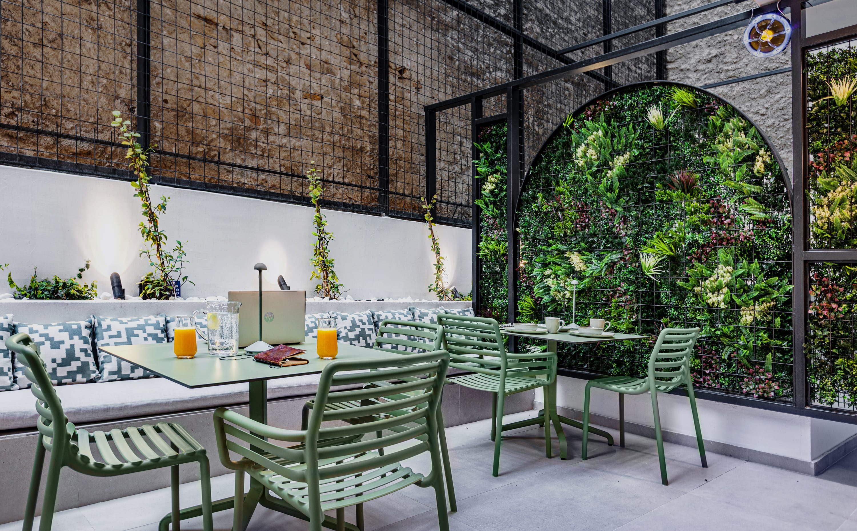a table with green chairs and a green table with a plant on it