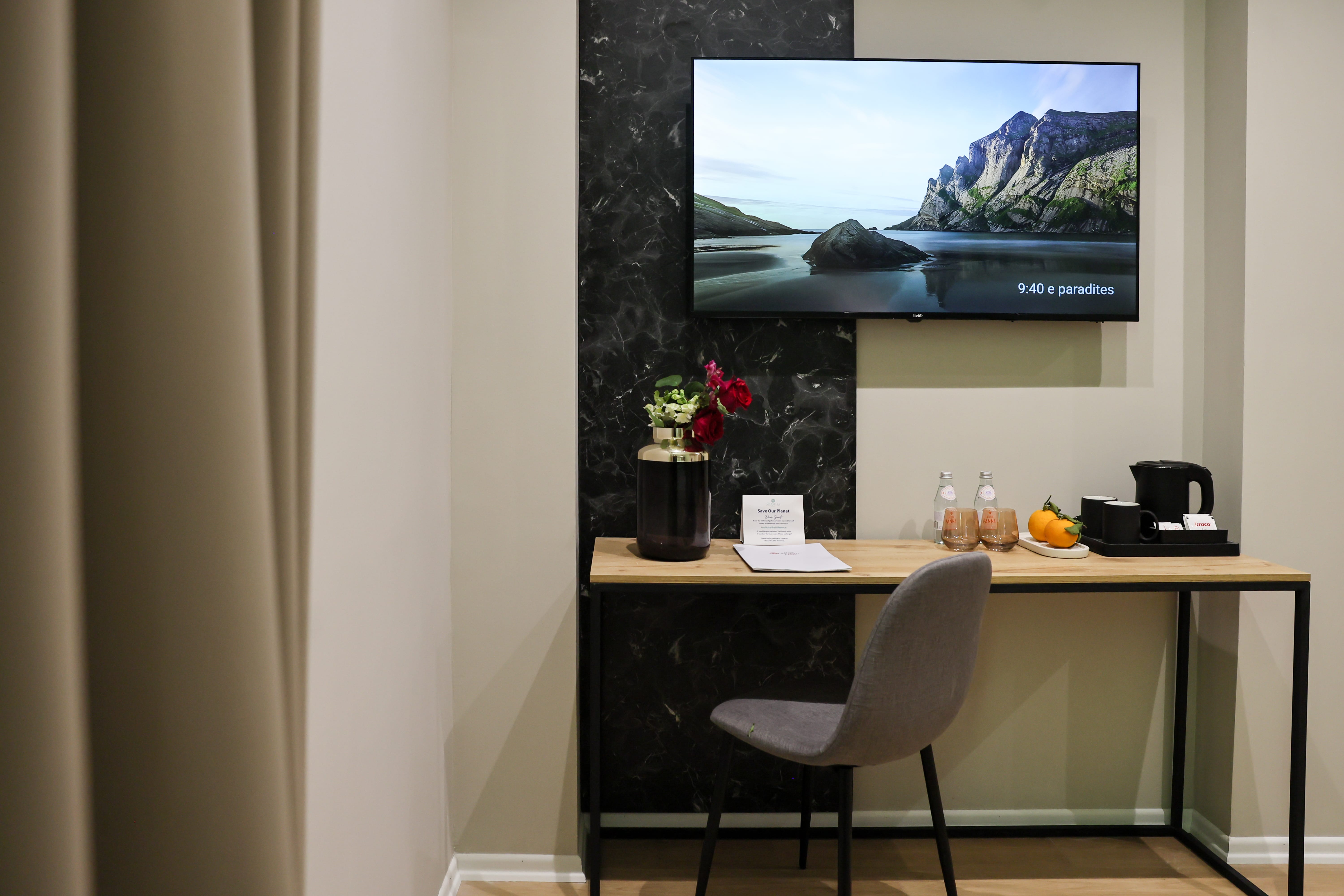 a desk with a chair and a television in the background