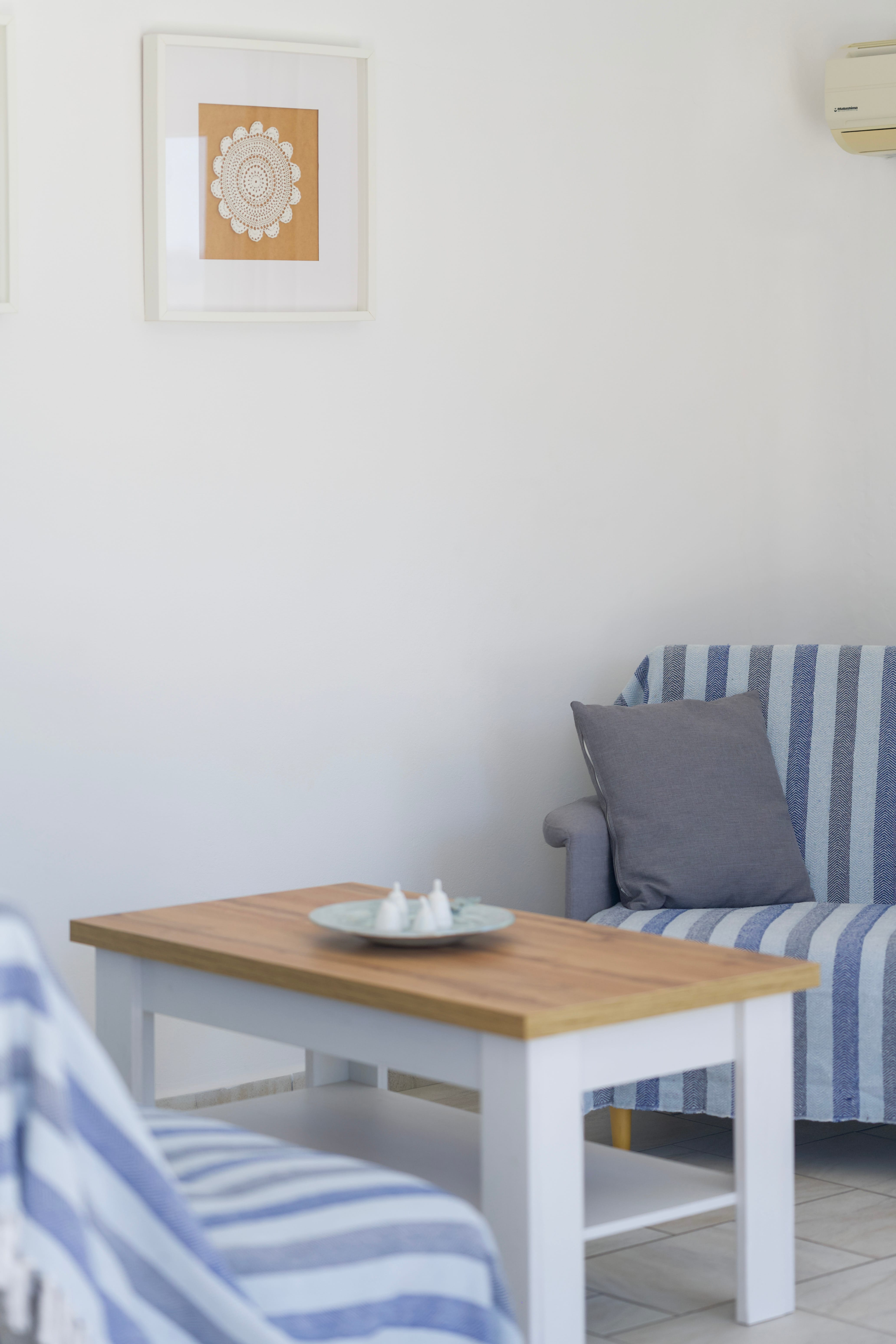 a table with a chair and a pillow in a room with pictures on the wall