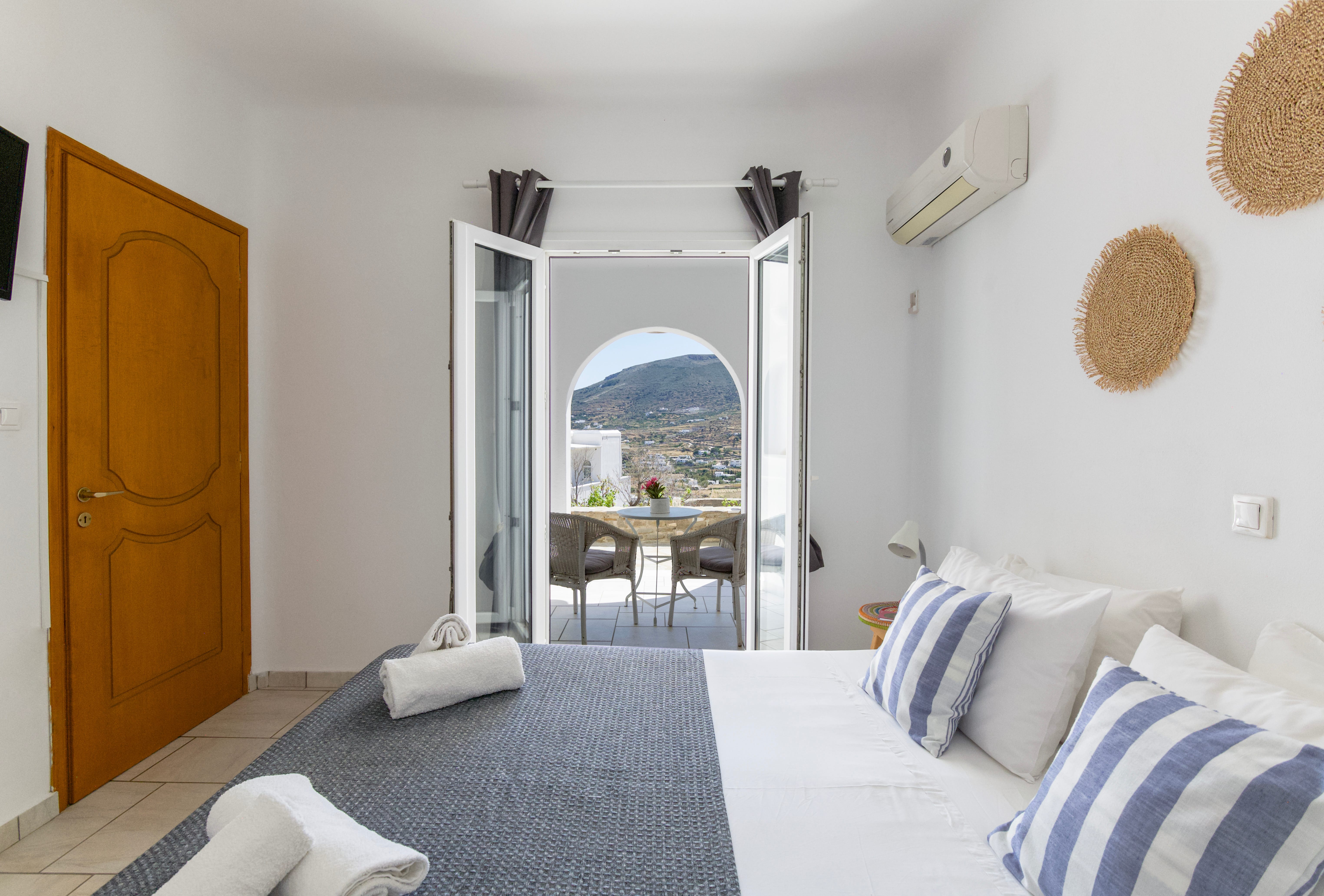 a room with a bed and a table with a door and a window