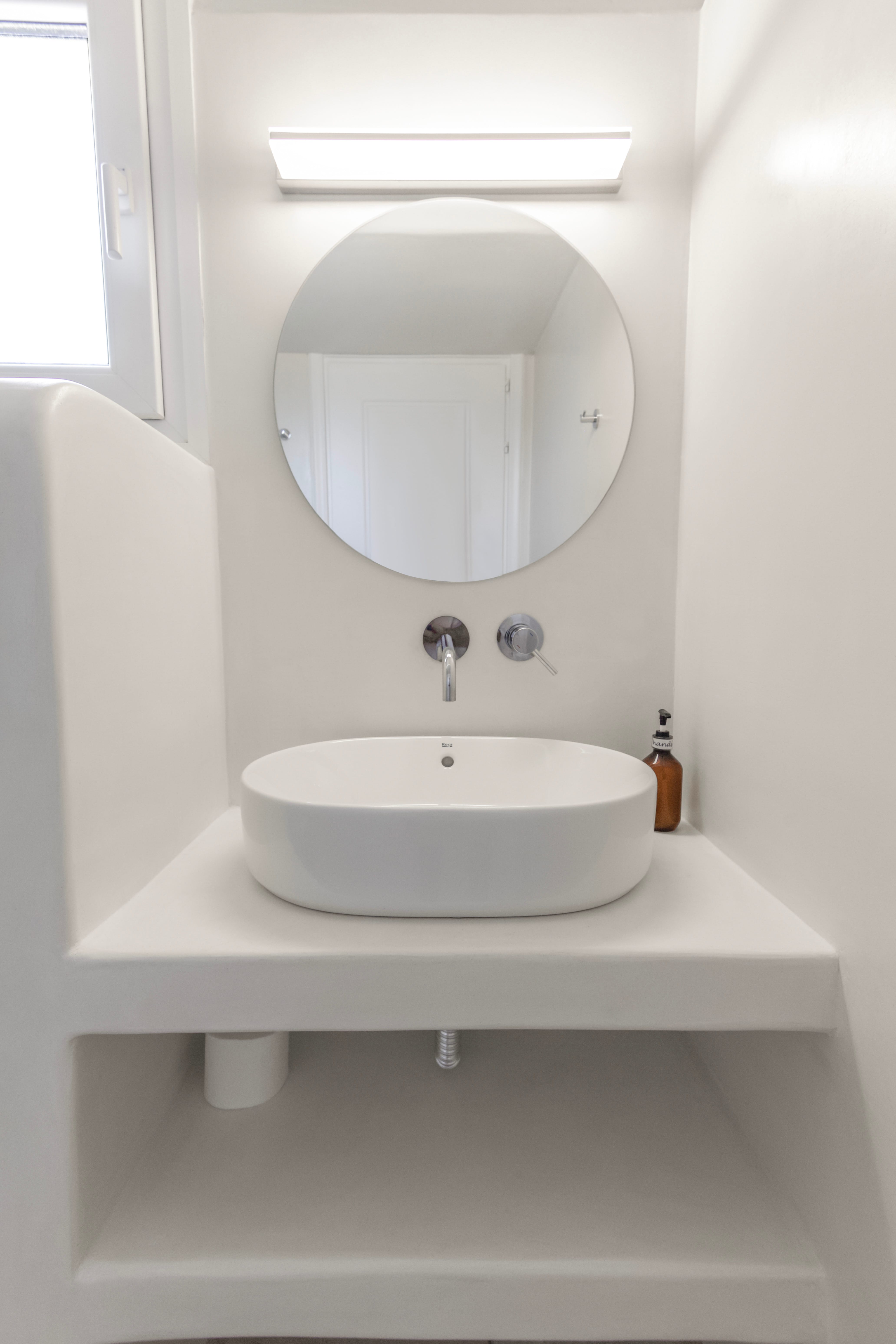 a white sink with a mirror above it