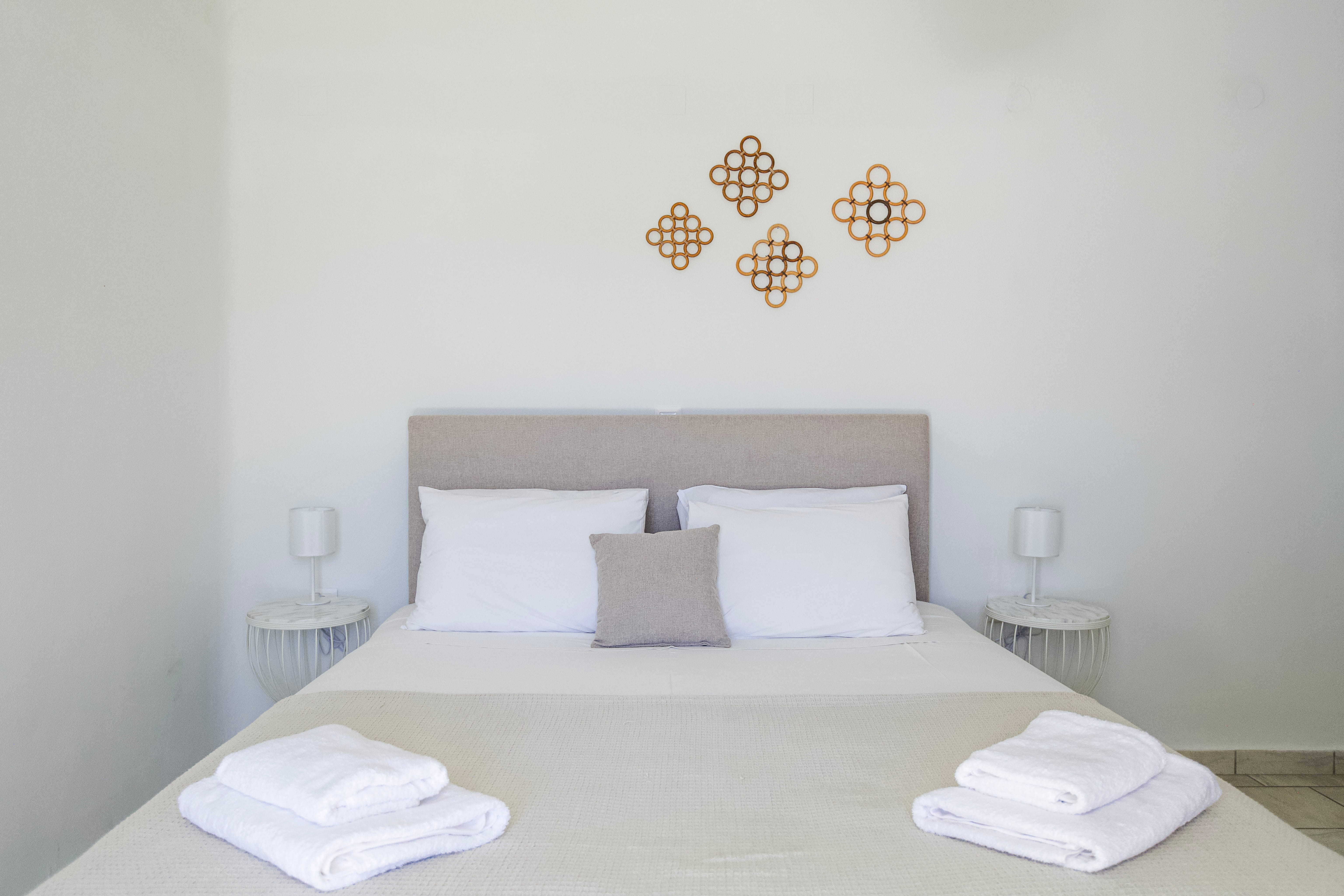 a bed with white sheets and pillows