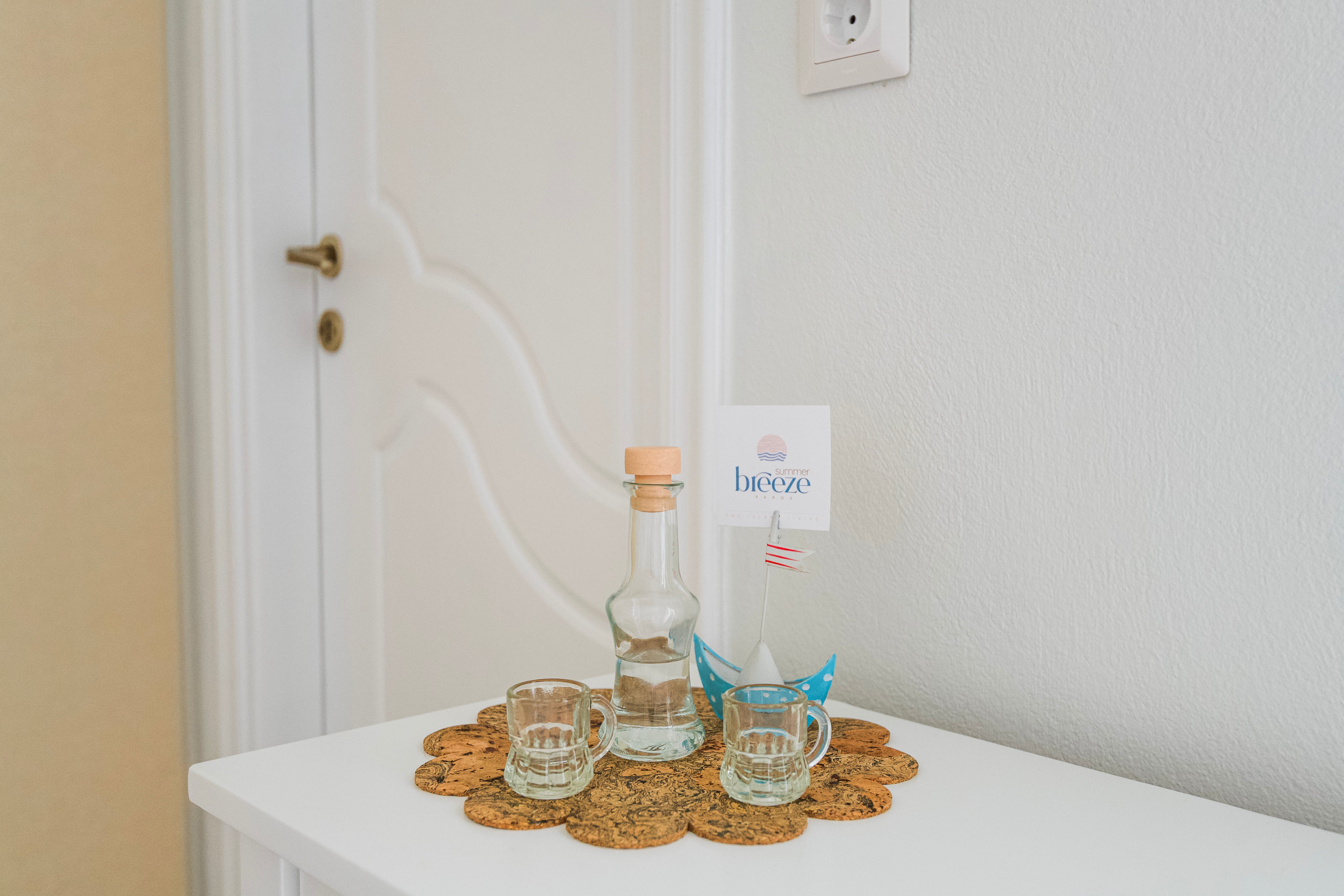 a counter with a bottle of liquid and a glass of water on it