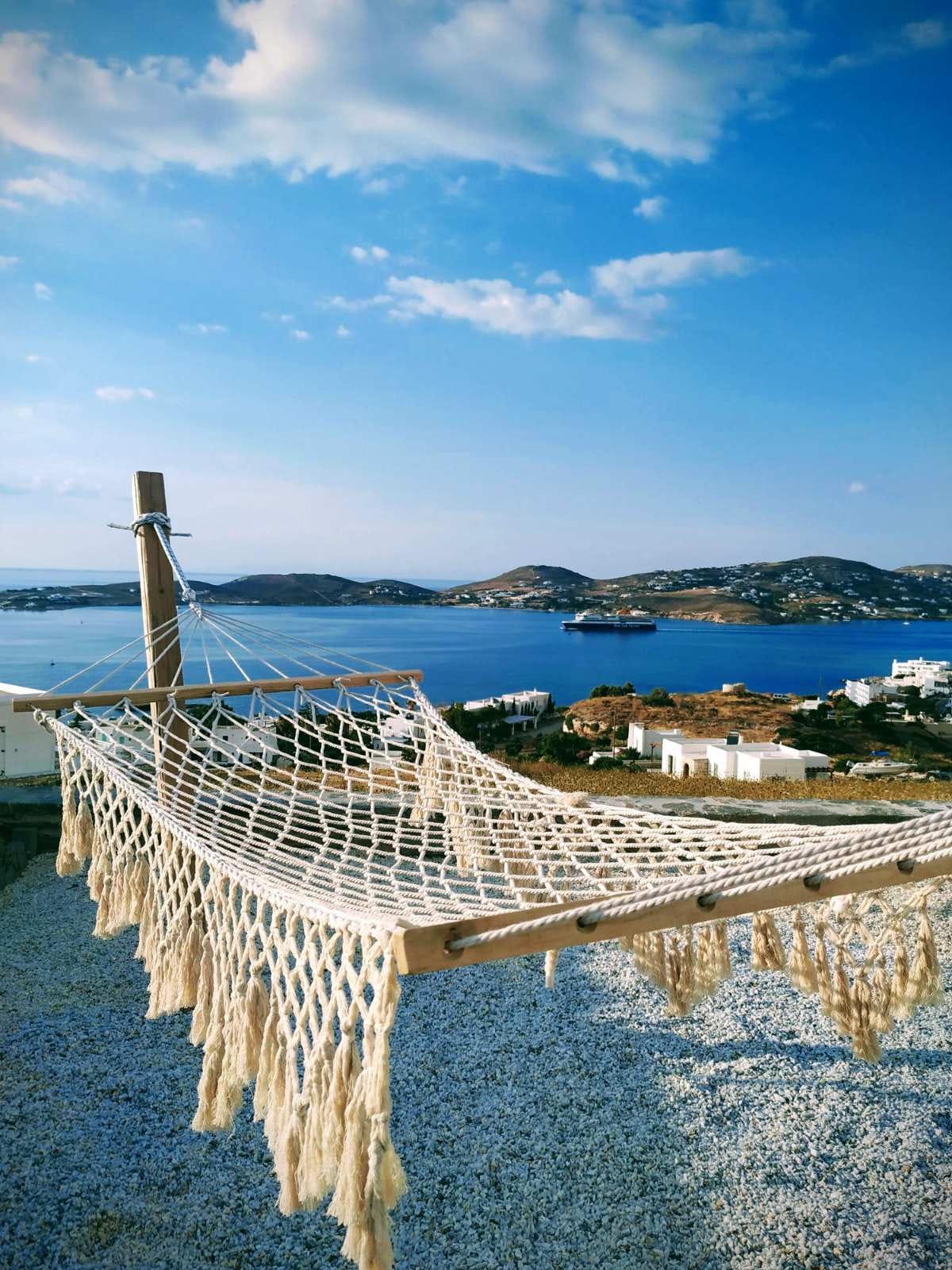 a hammock on a railing overlooking a body of water