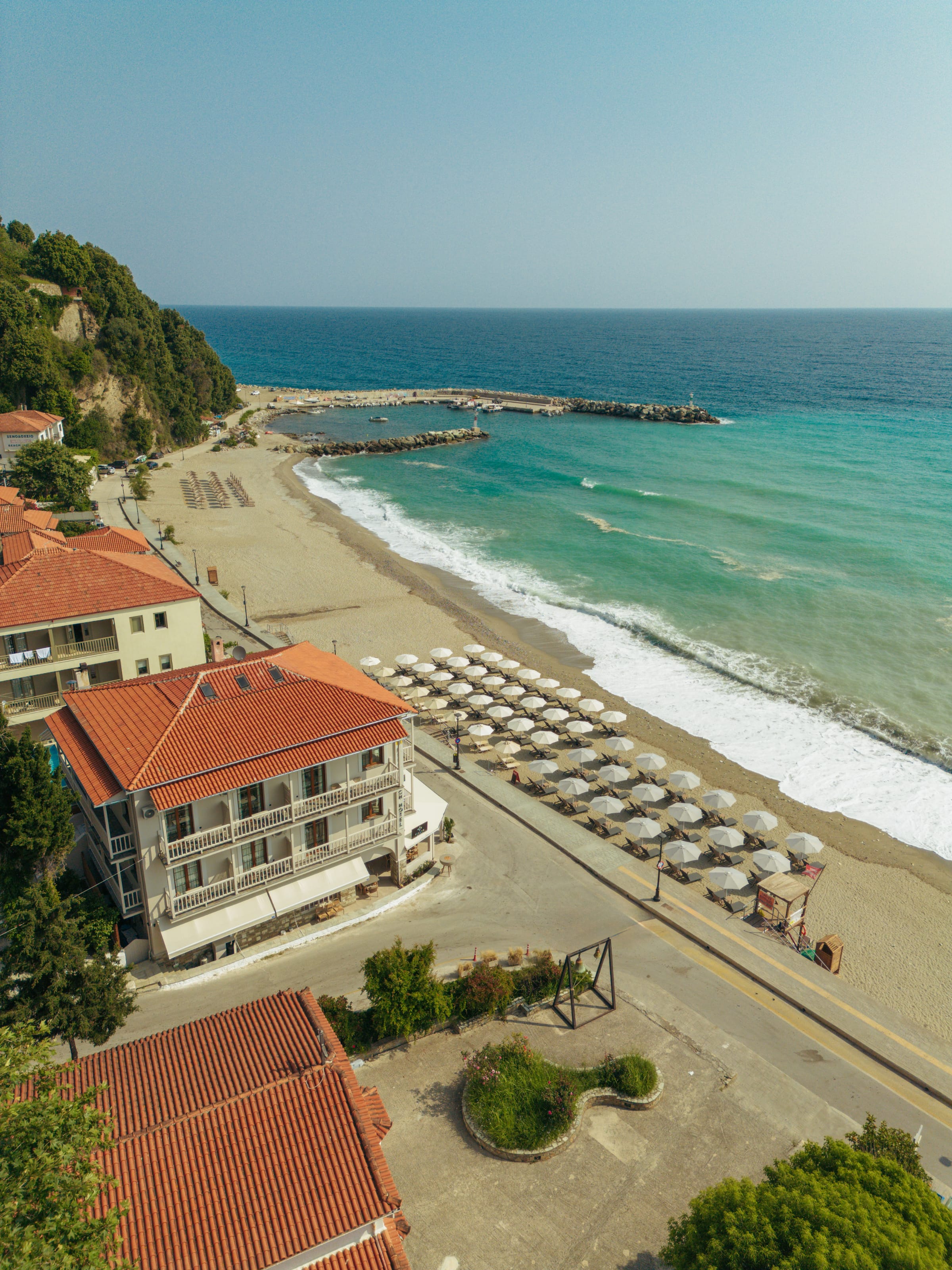 a beach with a building and a body of water
