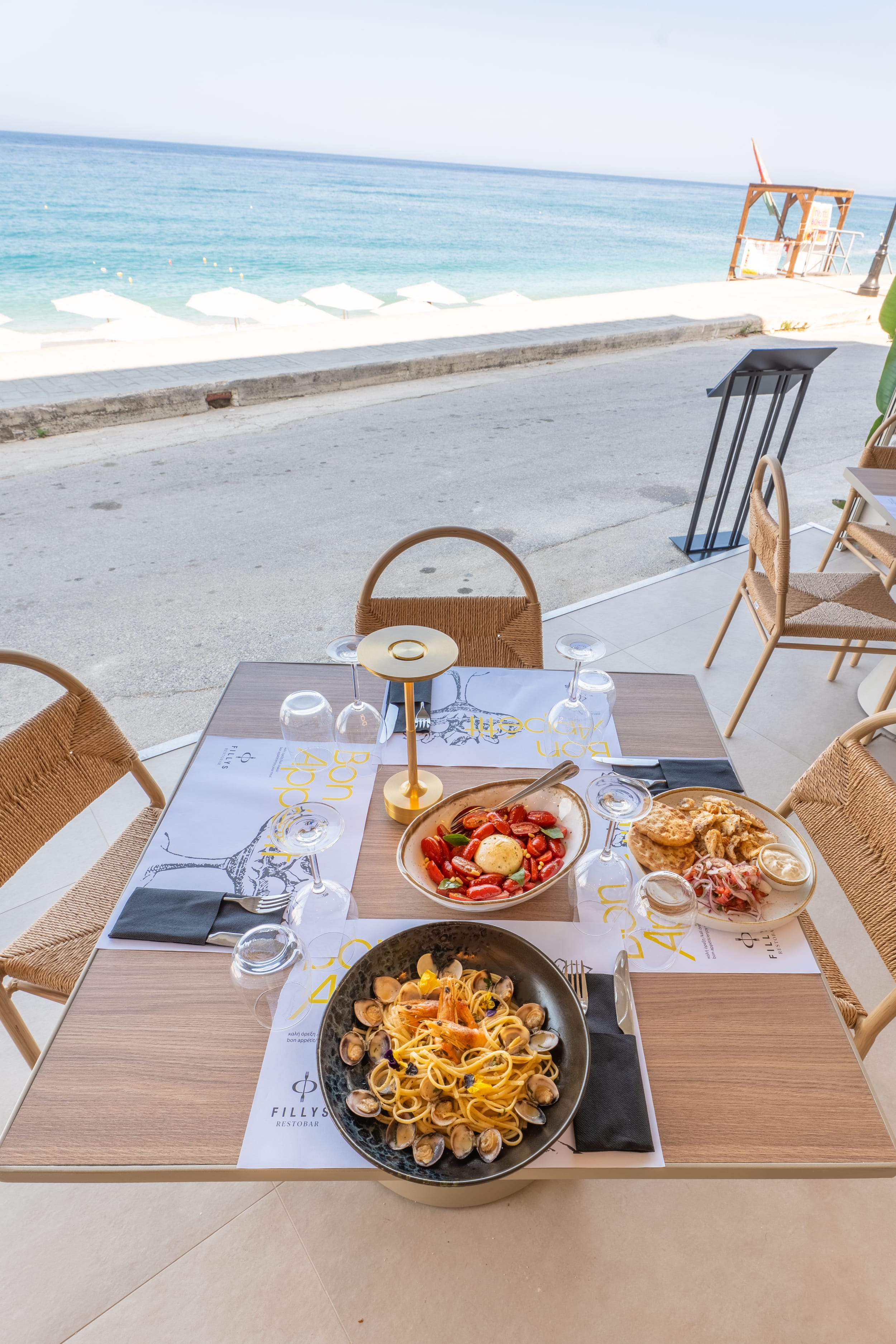 a table with food and drinks on it by a beach