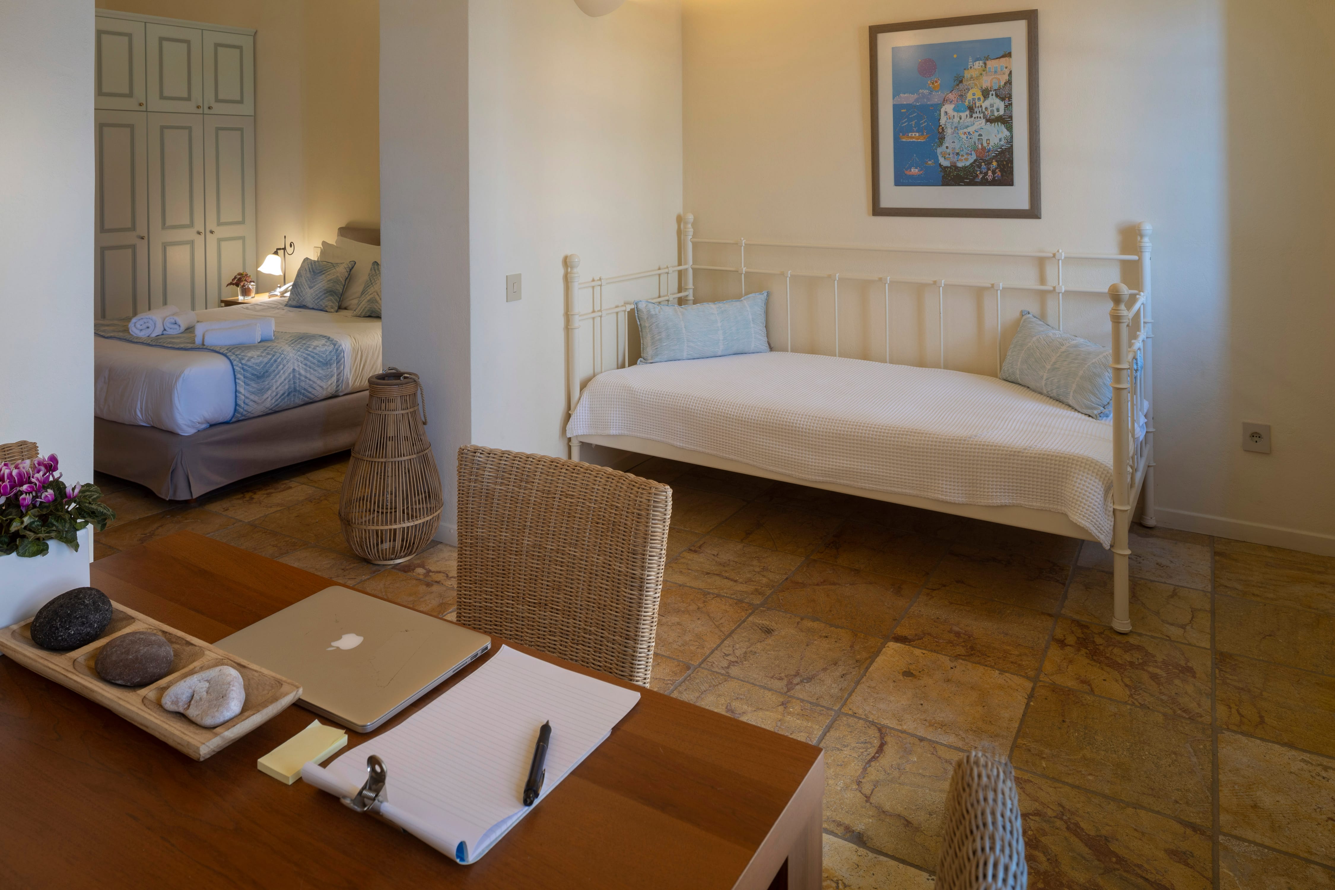 a bedroom with a bed and a laptop on the table