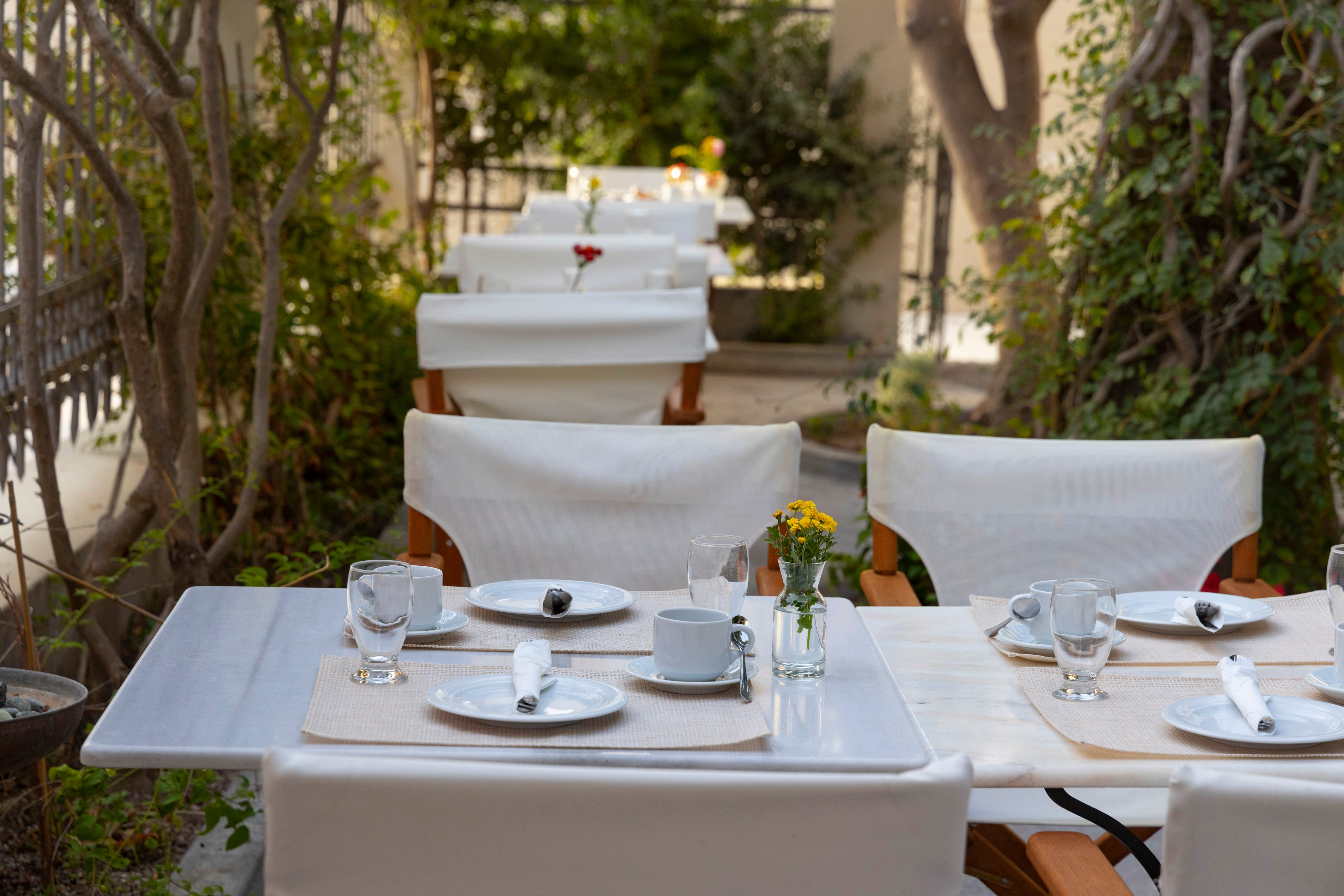 a table set with white chairs and white tables