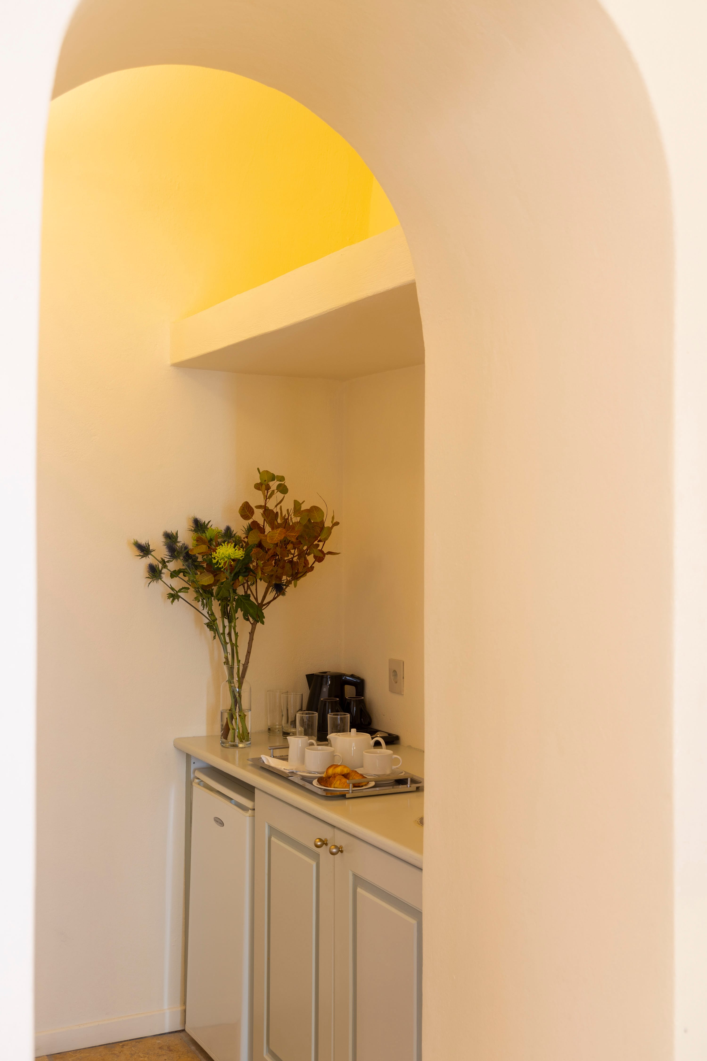 a vase with yellow flowers on a counter