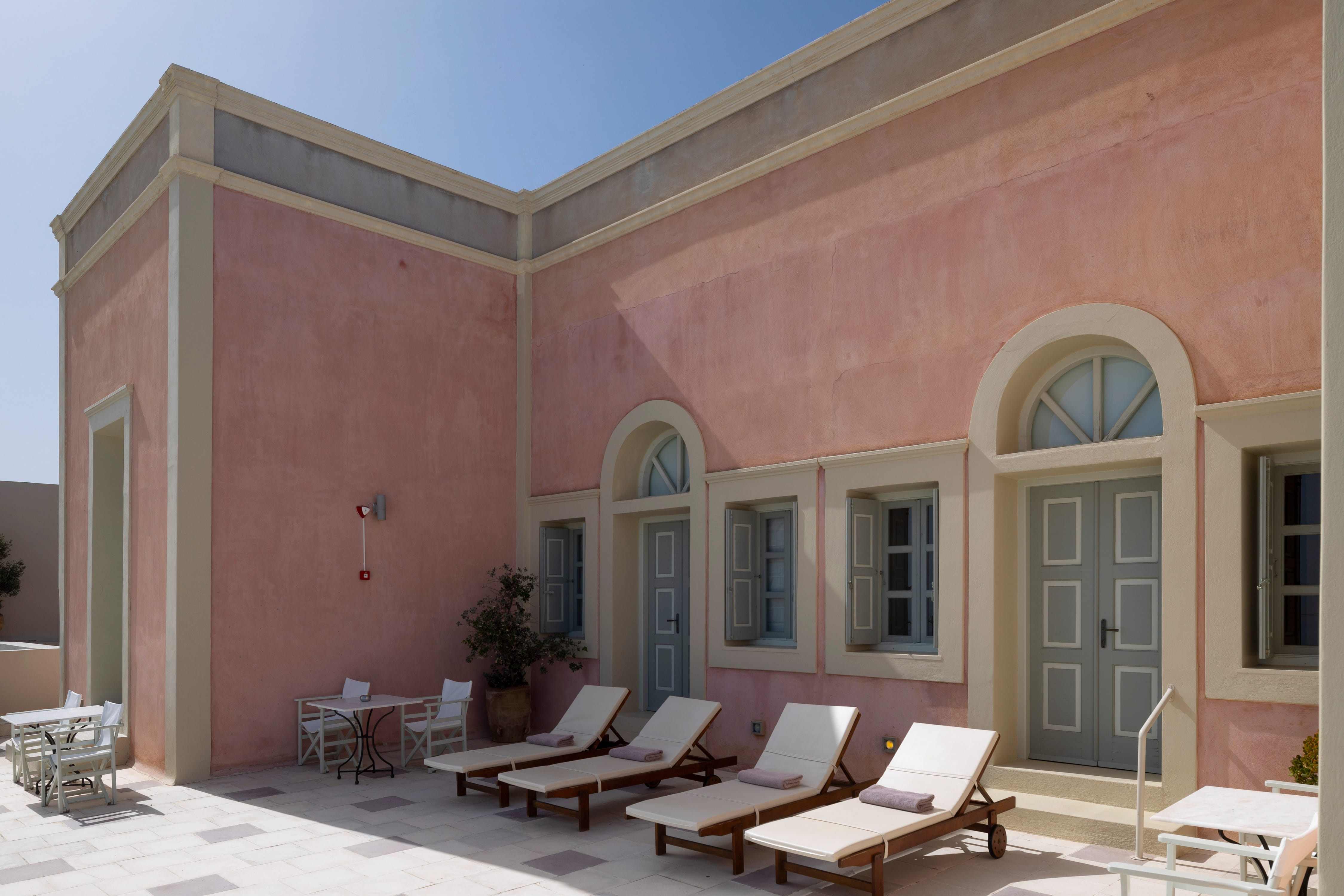 a pink house with a patio and chairs