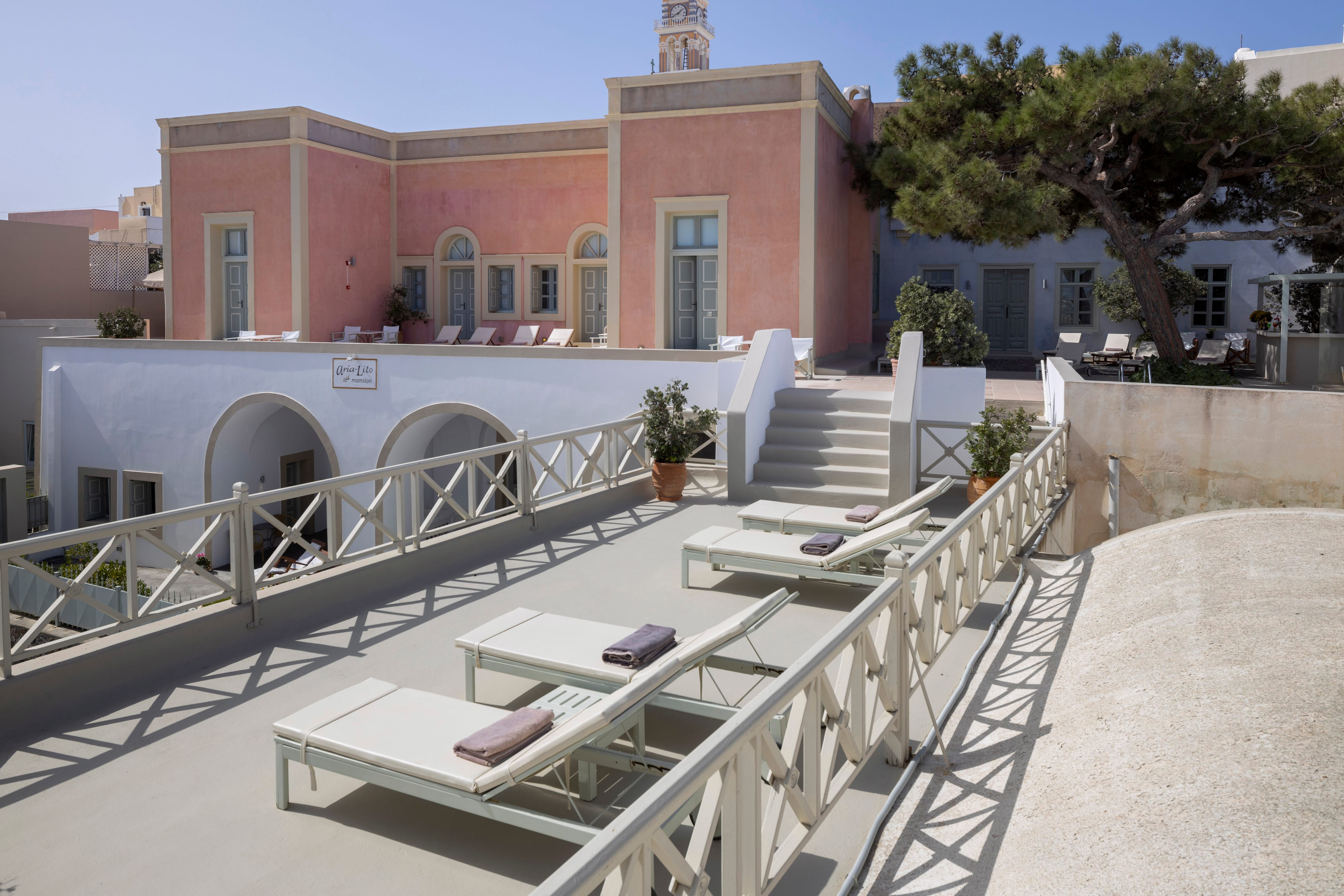a building with a pool and lounge chairs