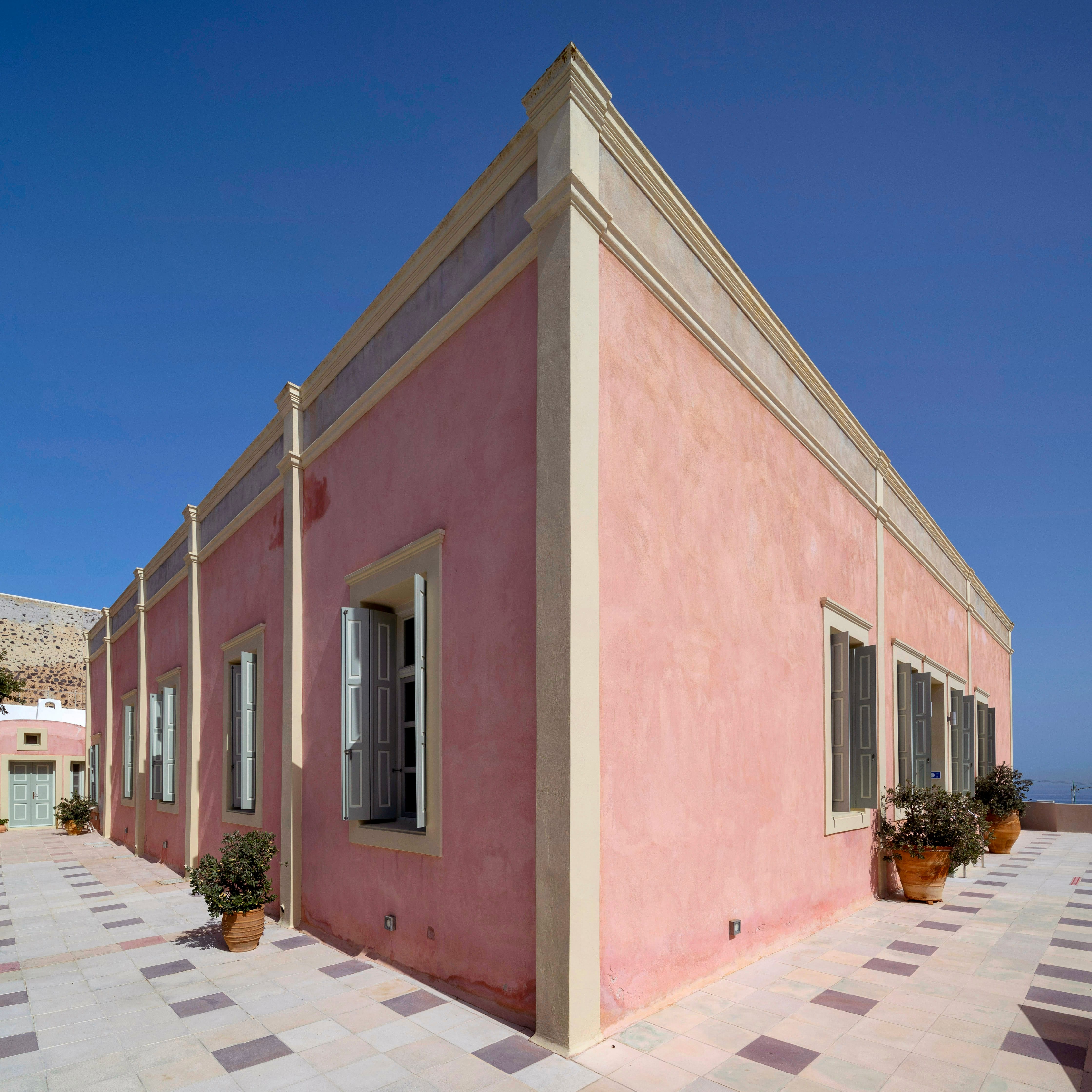 a pink building with a brick walkway