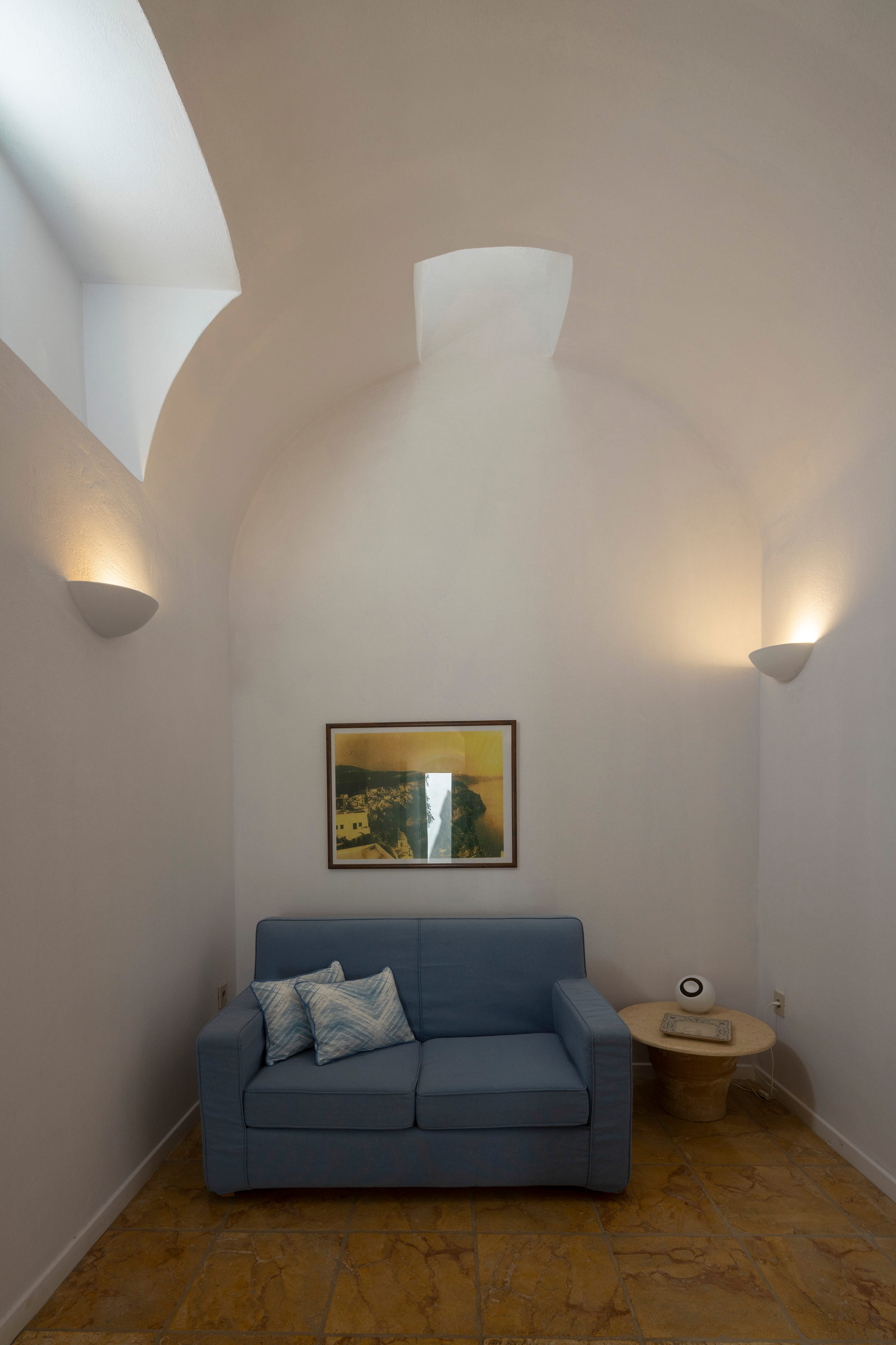 a room with a couch and a painting on the wall