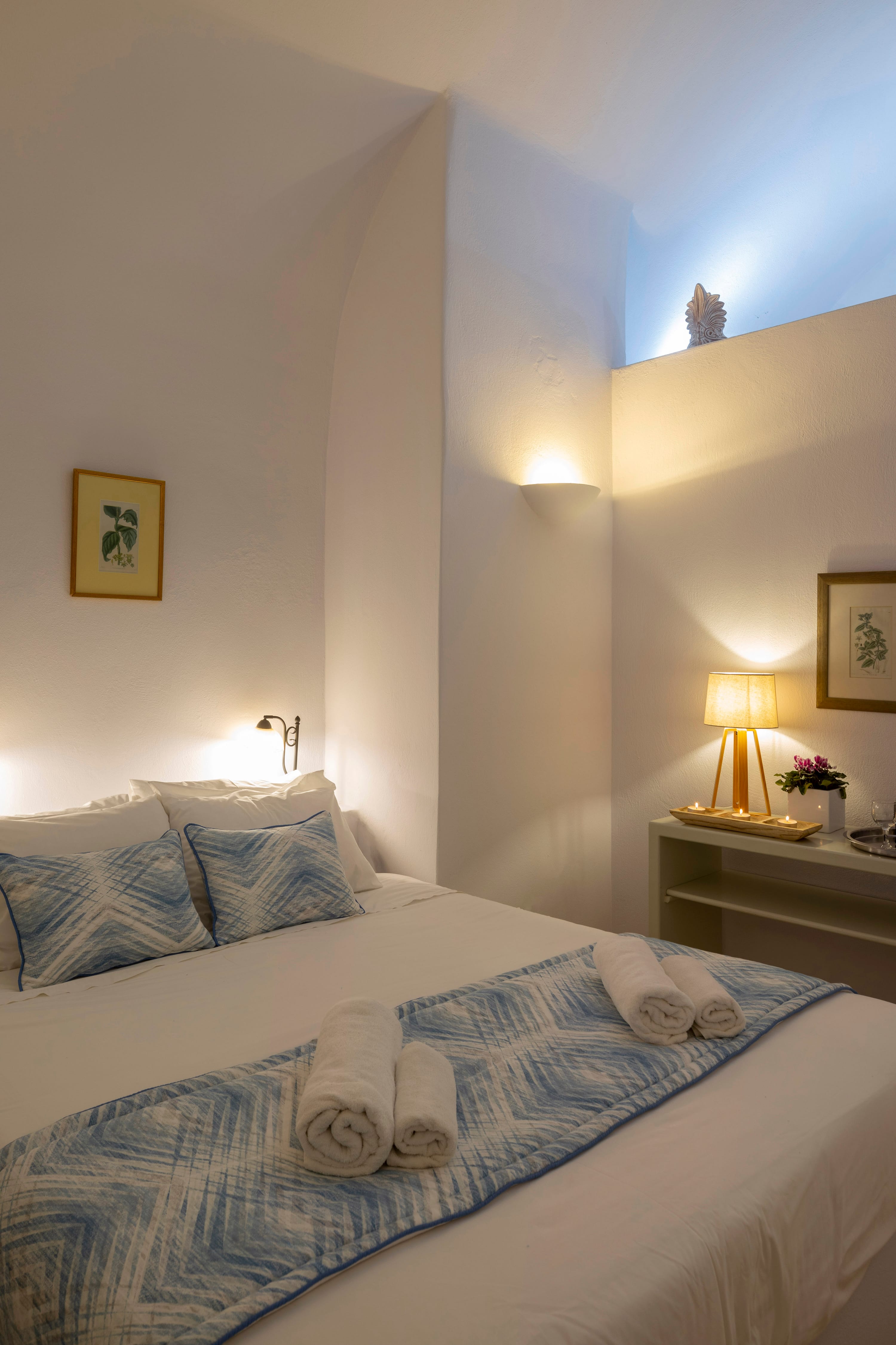 a bed with white sheets and pillows