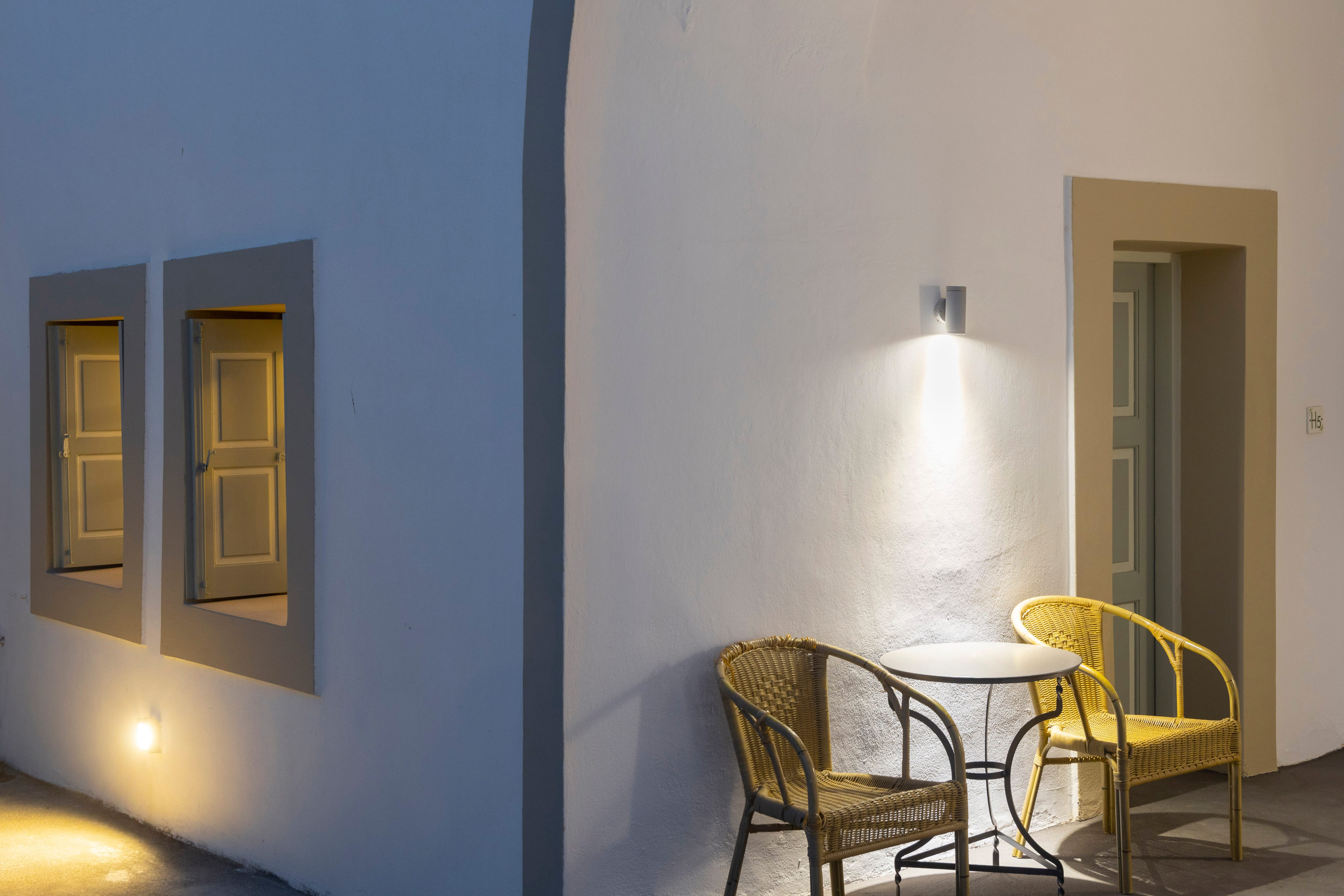 a room with a table chairs and a lamp