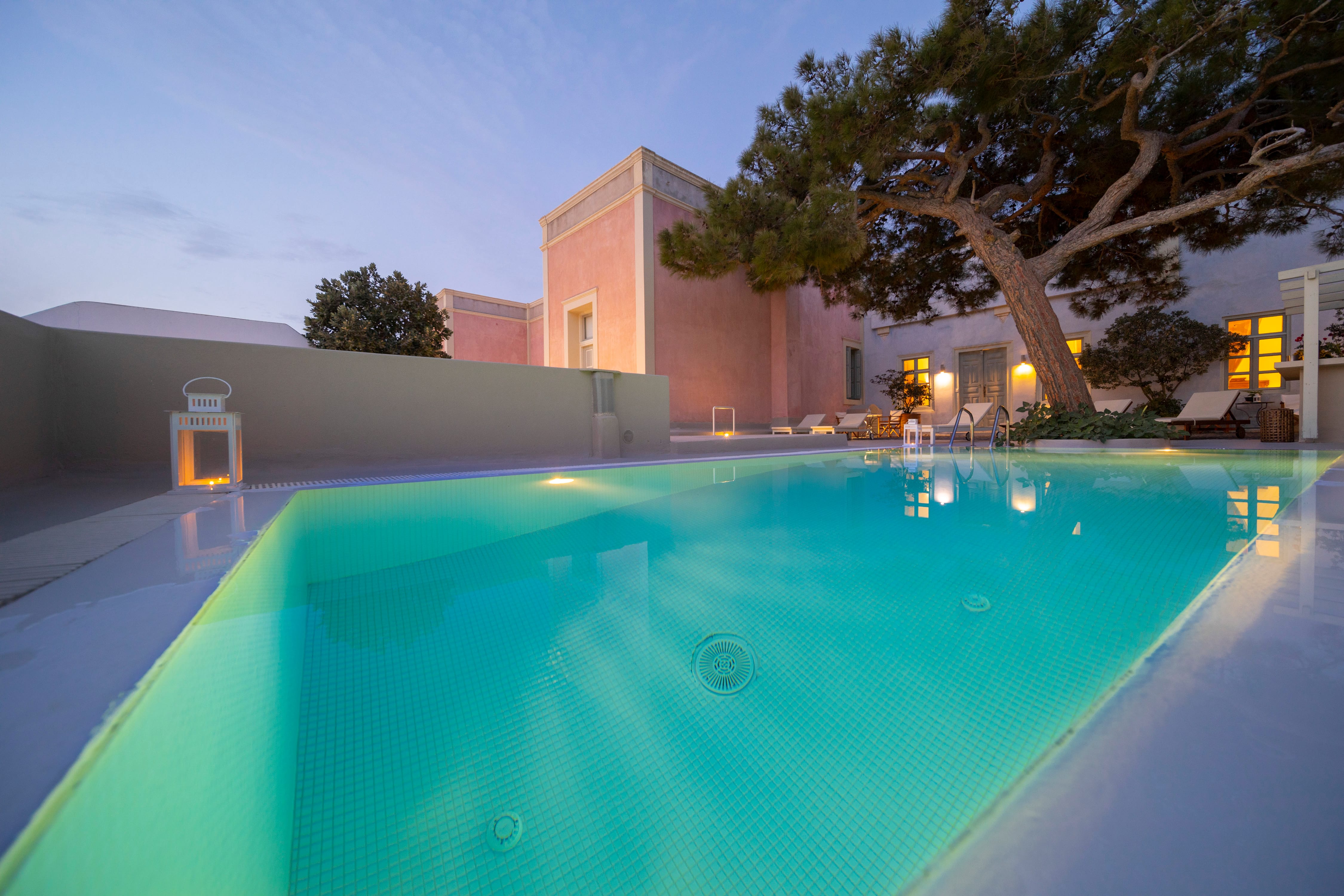 a pool with a tree and buildings in the background