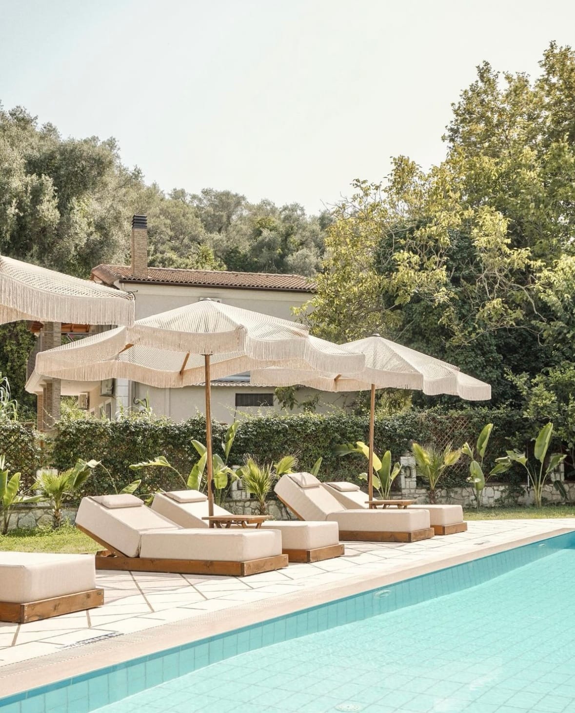 a pool with lounge chairs and umbrellas by it