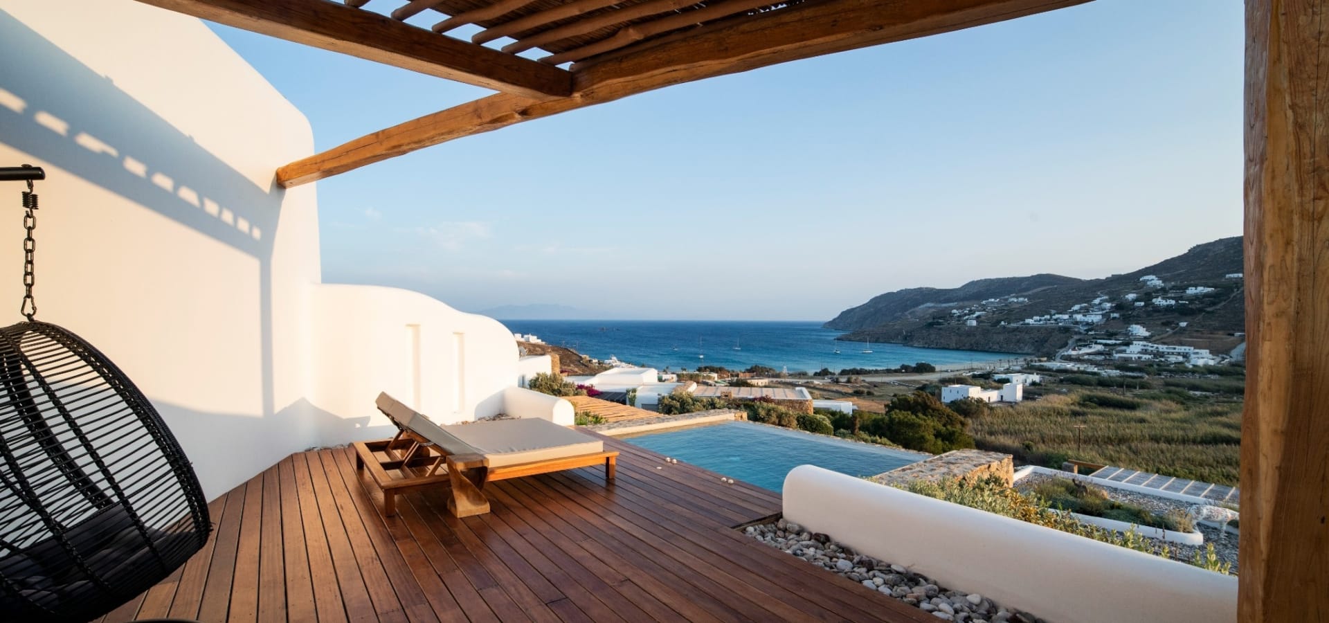 a deck with a pool and mountains in the background