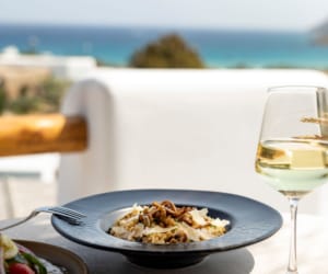 a plate of food and a glass of wine on a table