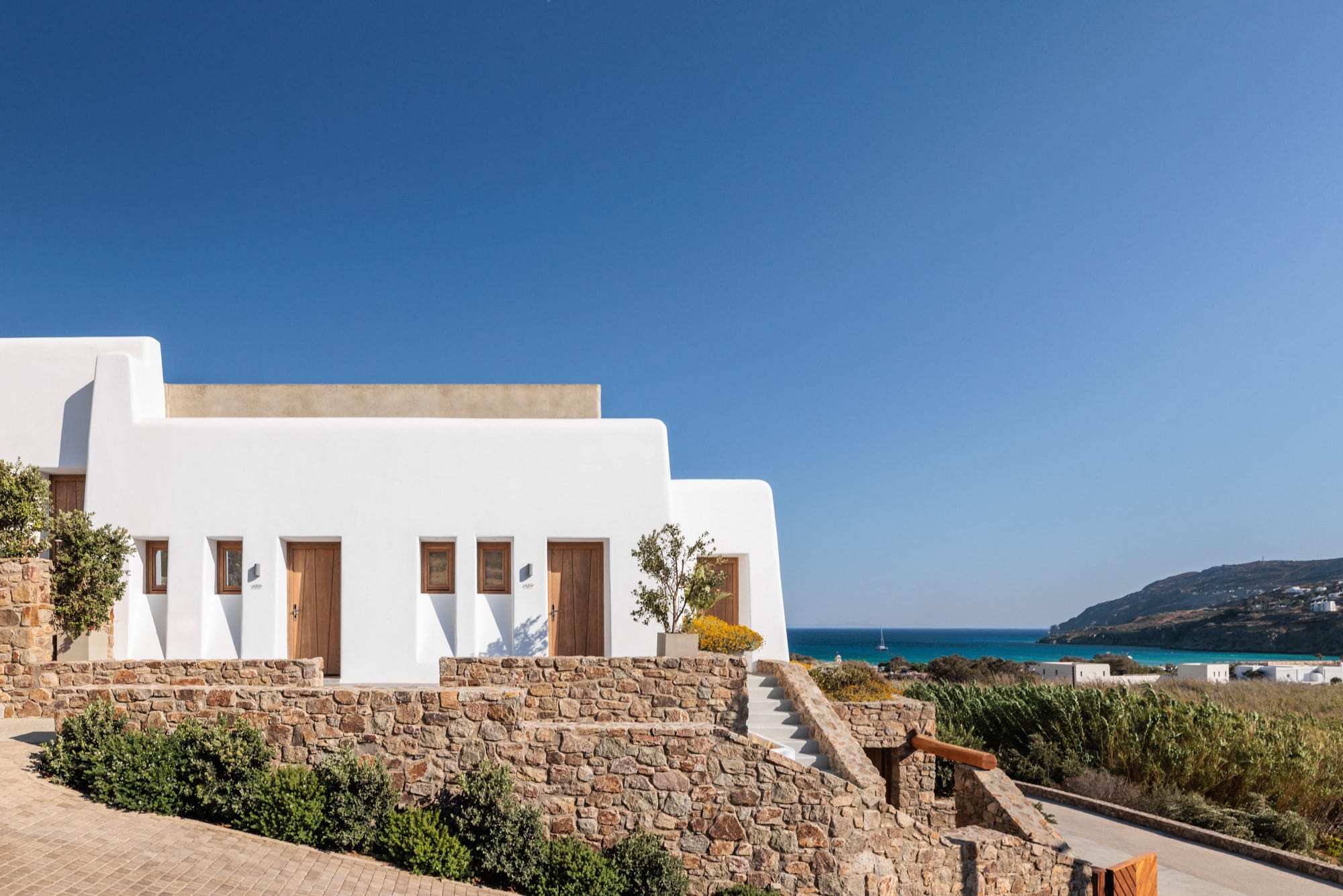 a white house with a stone wall