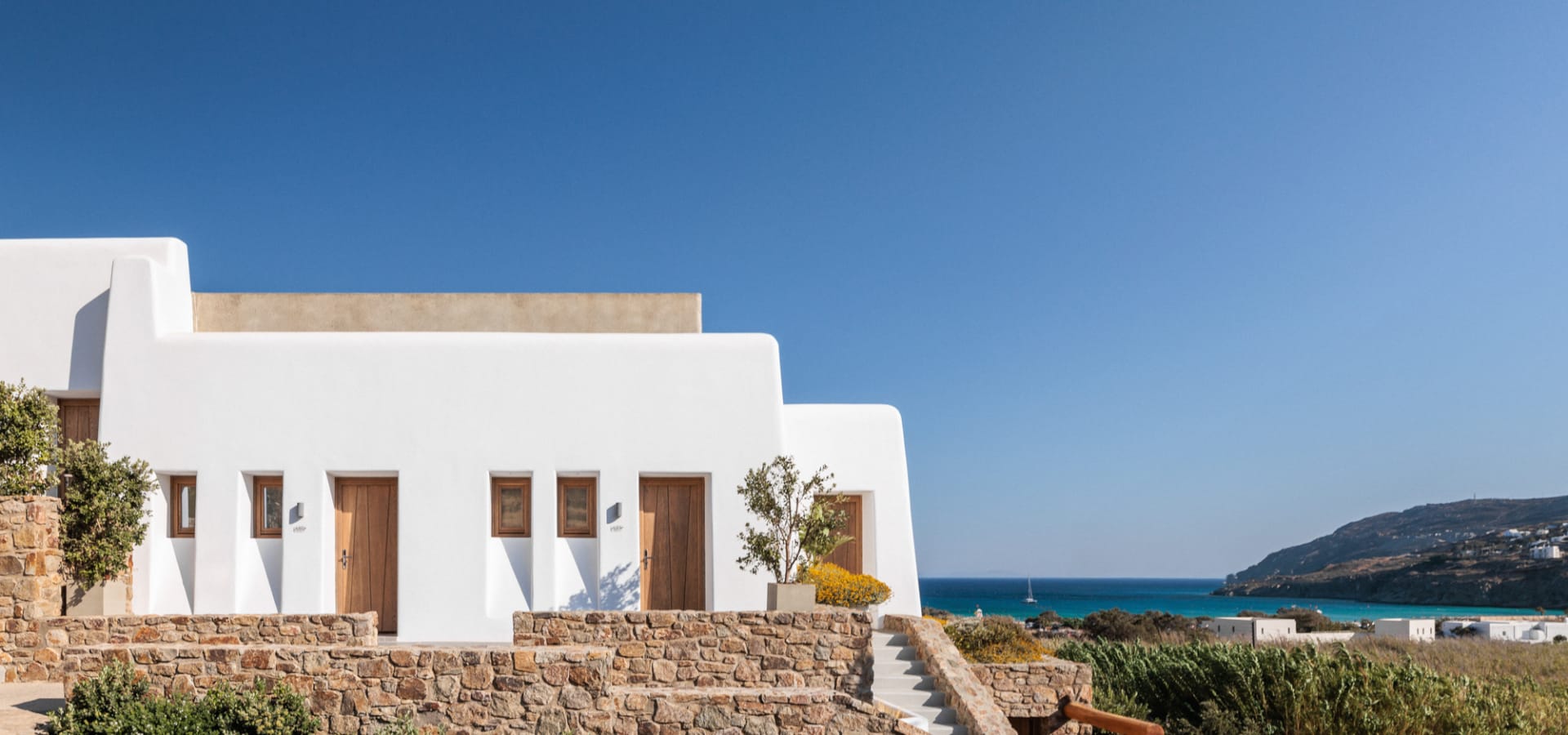 a white house with a stone wall