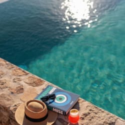 a pair of flip flops on a rock by a body of water