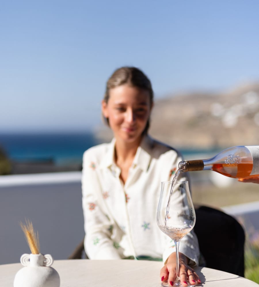 a person sitting at a table with a glass of wine