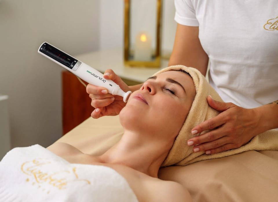 a person lying on a bed with a hair dryer