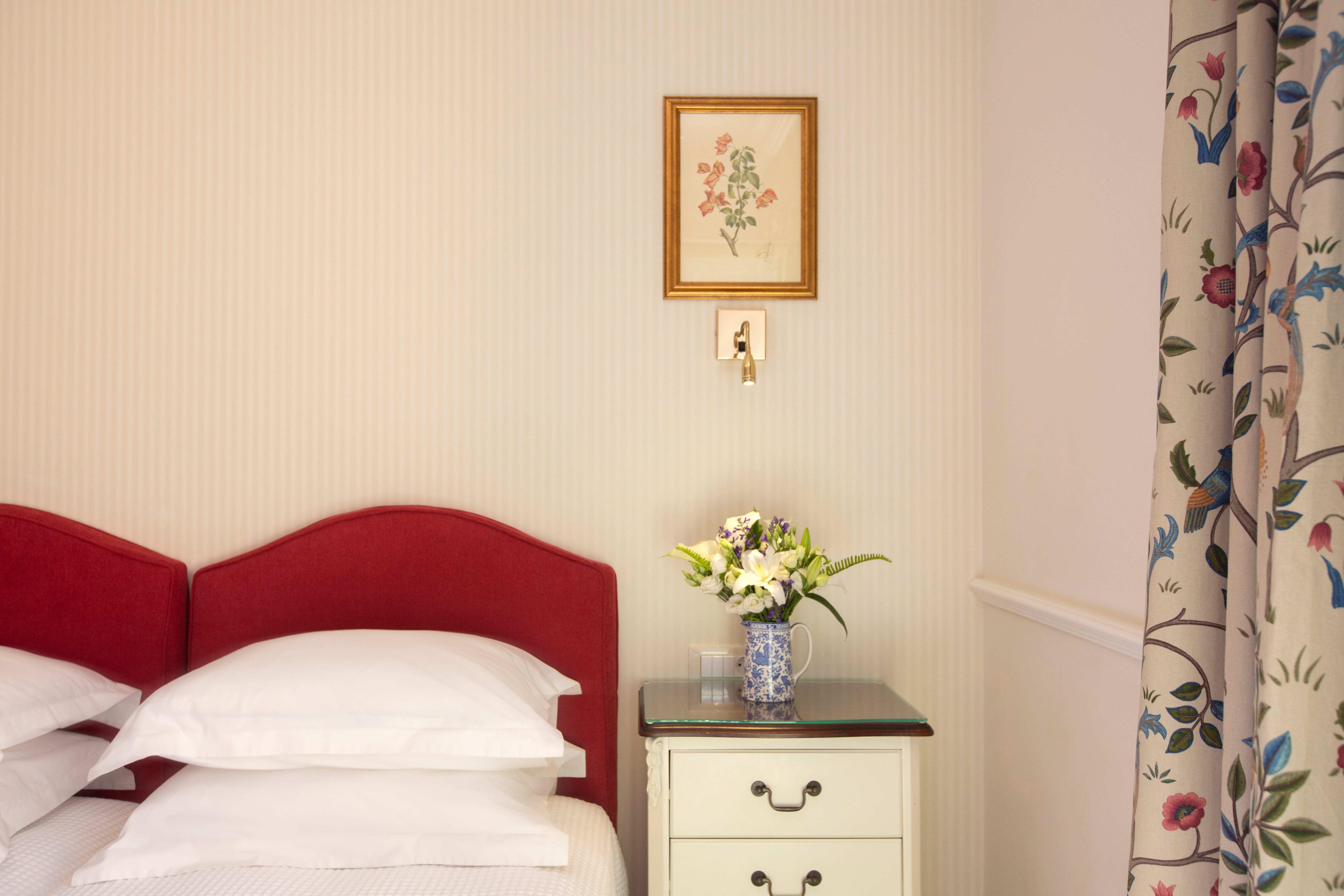 a bed with a vase of flowers on a table