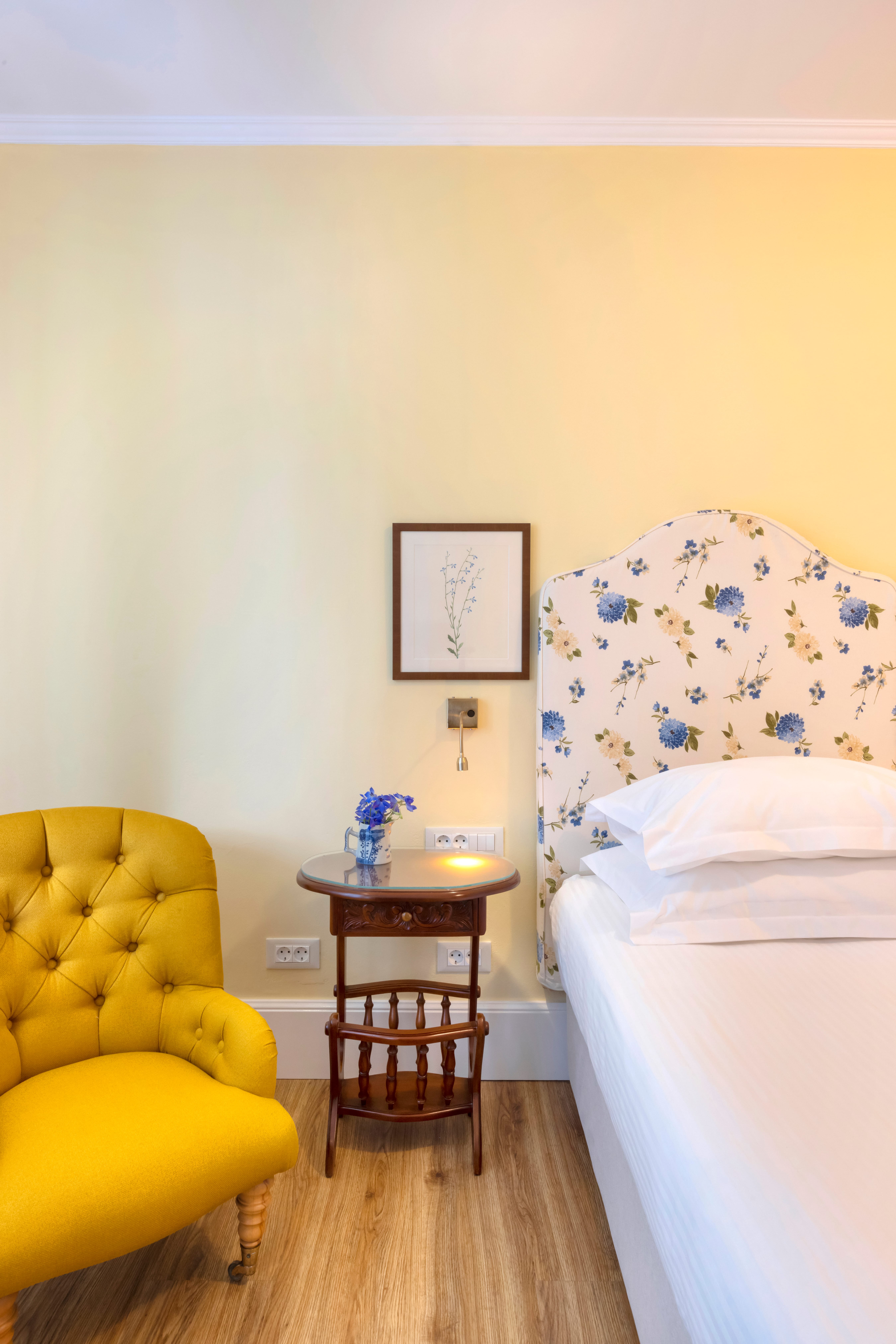 a yellow chair next to a bed