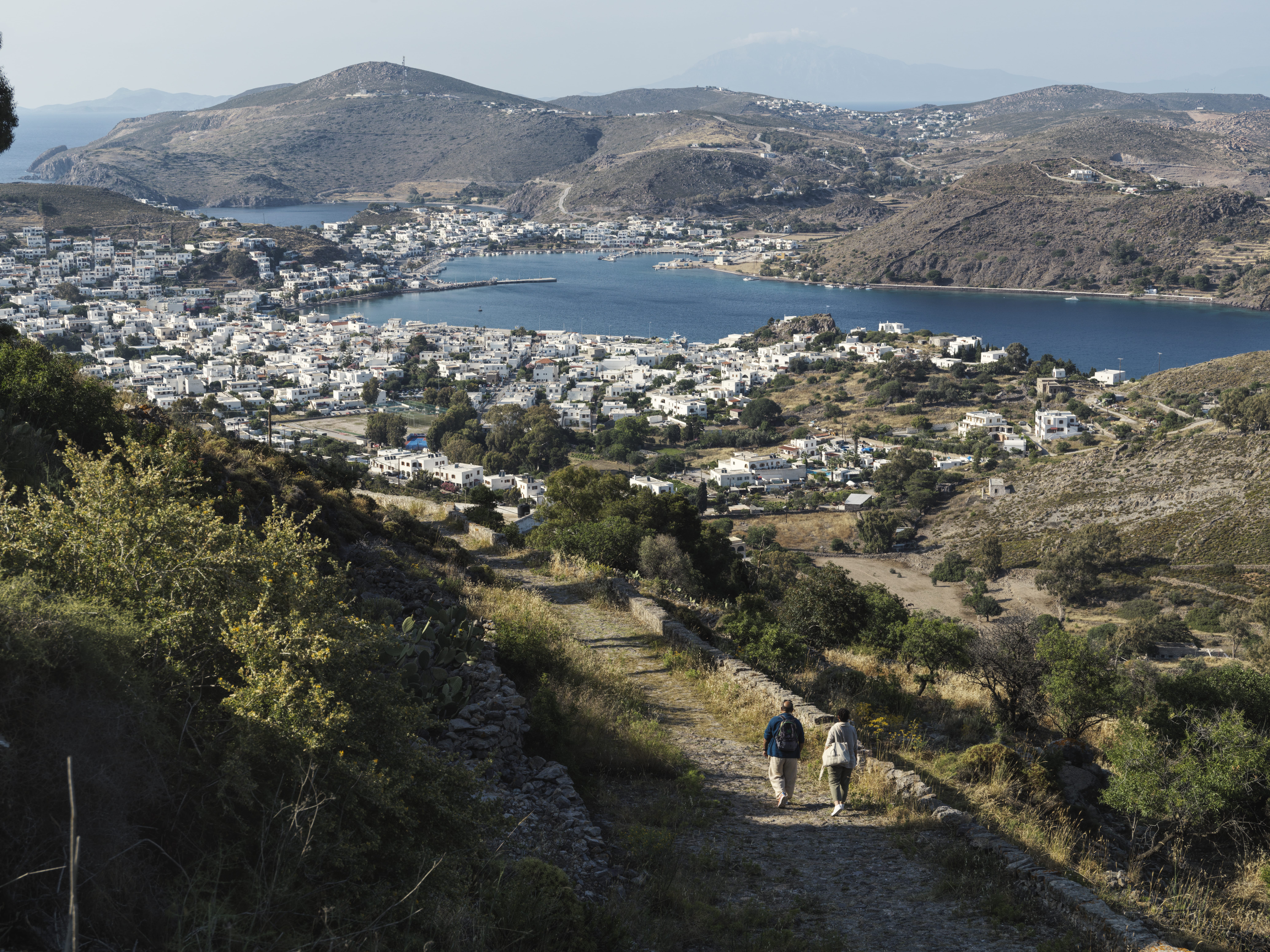 people walking on a path near a body of water