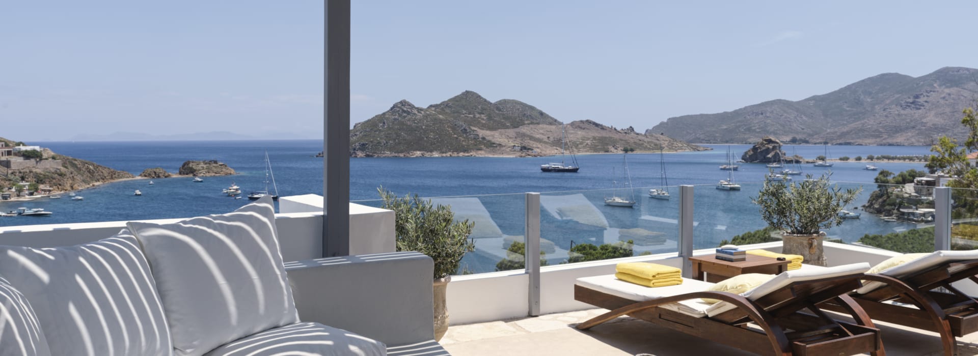 a patio with a table and chairs and a body of water in the background