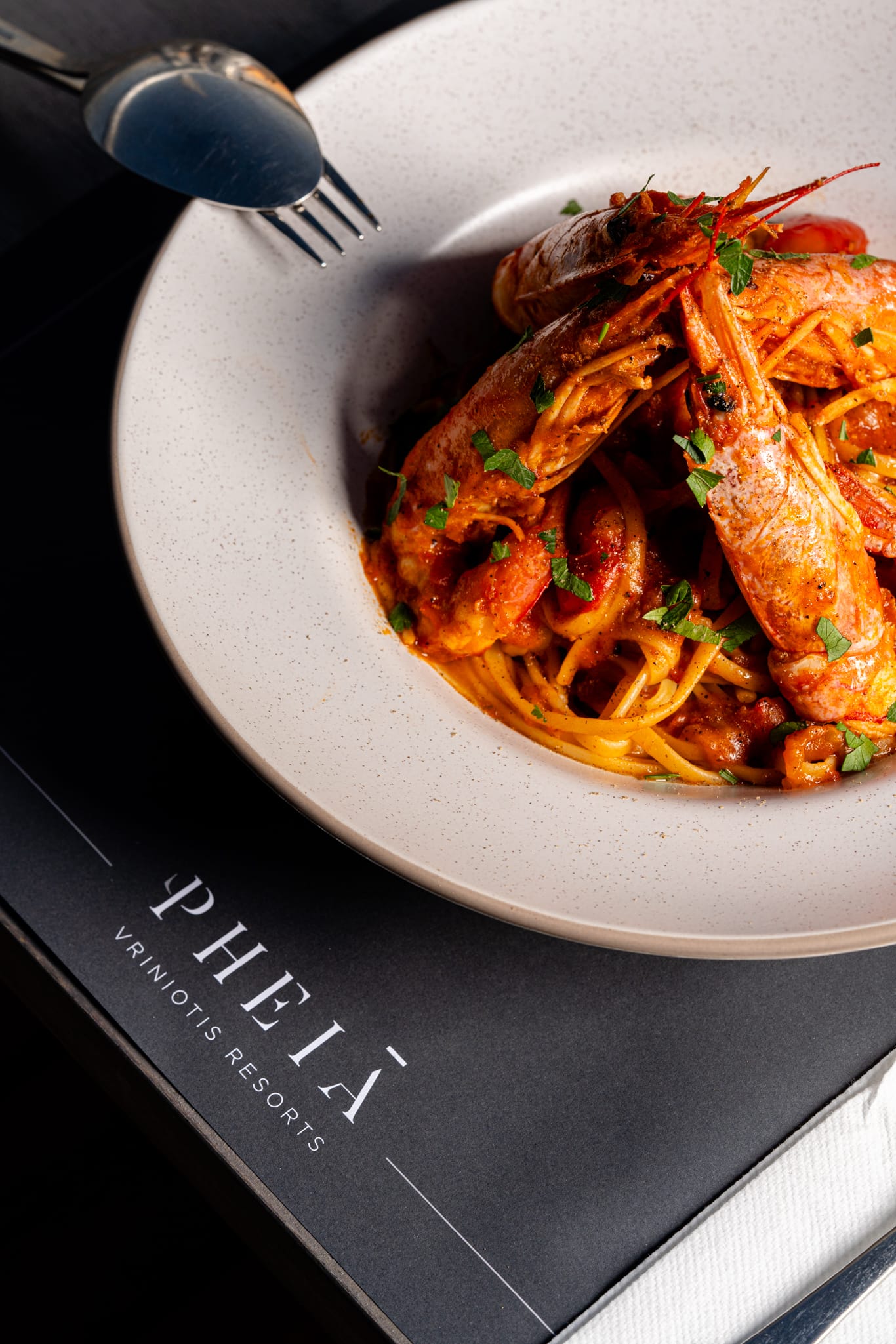 a bowl of pasta with shrimp and parsley