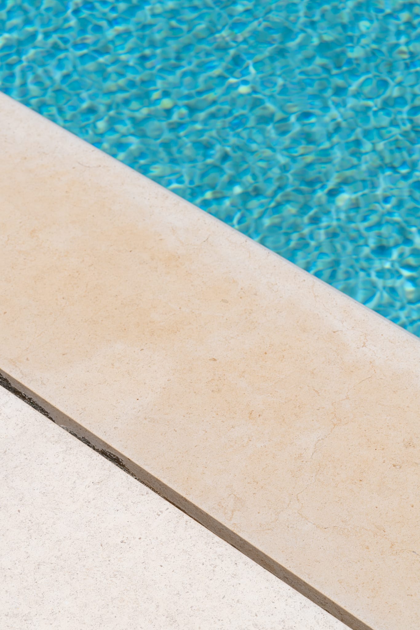 a pool edge with blue water