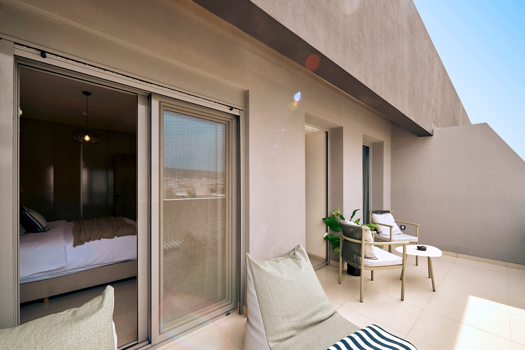 a patio with a chair and a bed