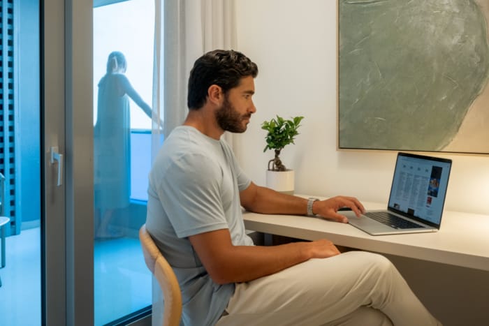 a person sitting at a desk using a laptop