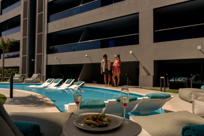 a couple standing next to a pool