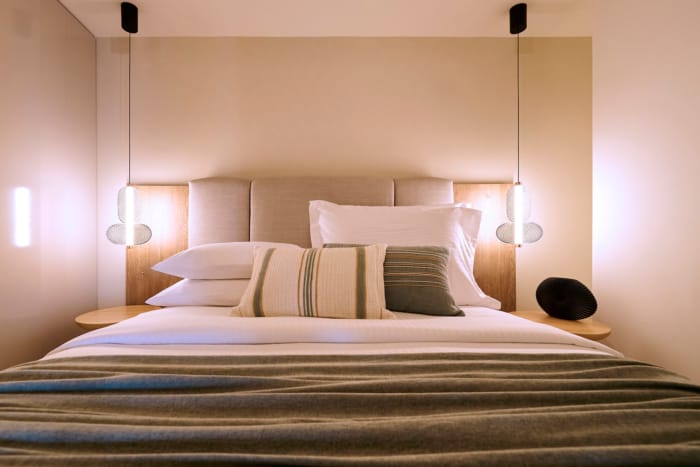 a bed with pillows and a lamp