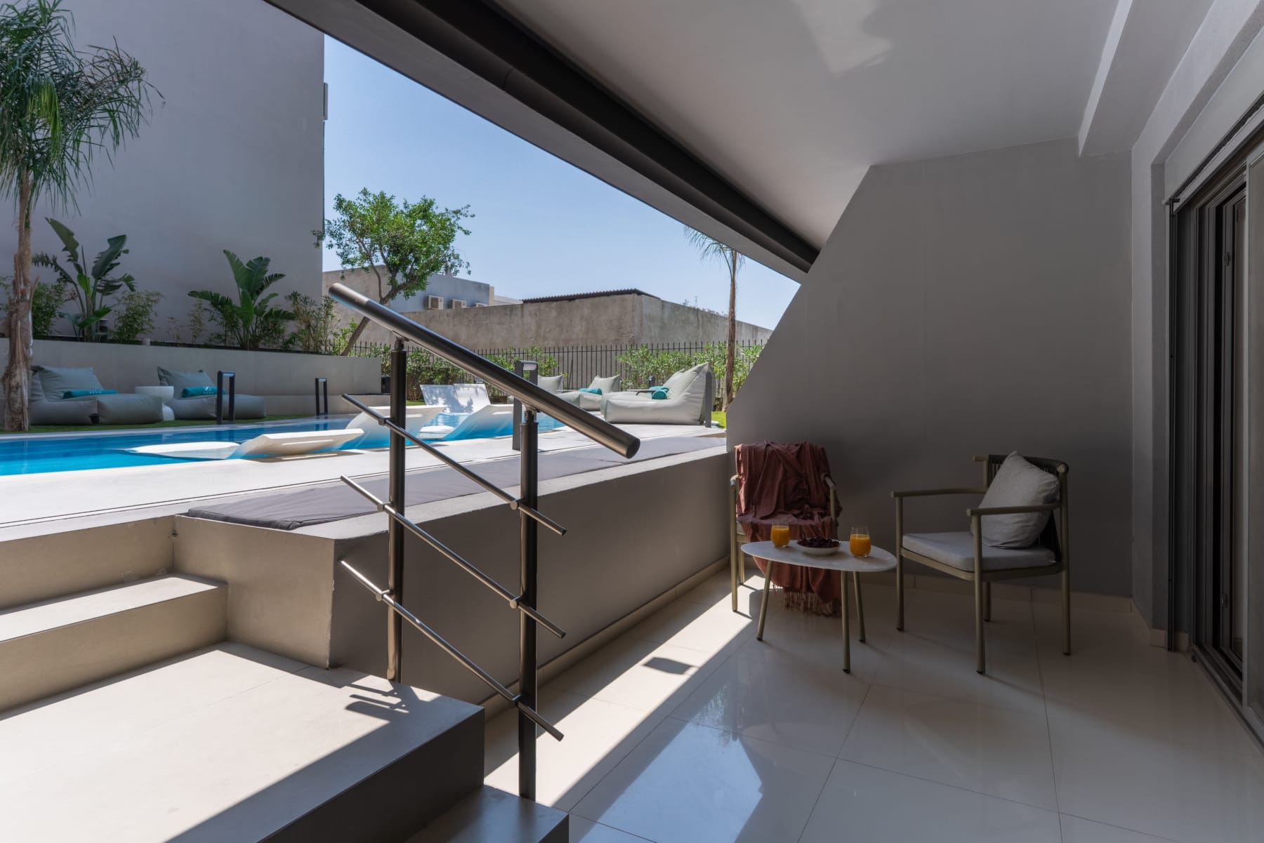 a patio with a pool and chairs