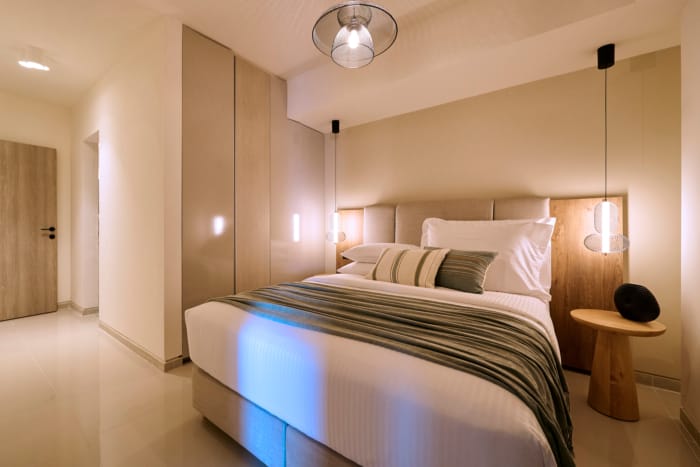 a bed with a lamp and a mirror