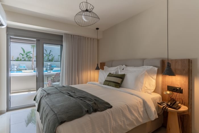 a bed with a light fixture and a glass door