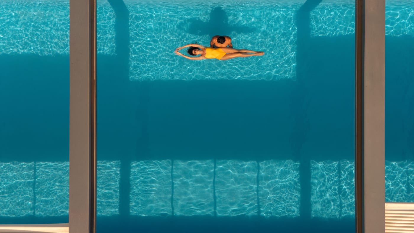 a couple of people swimming in a pool