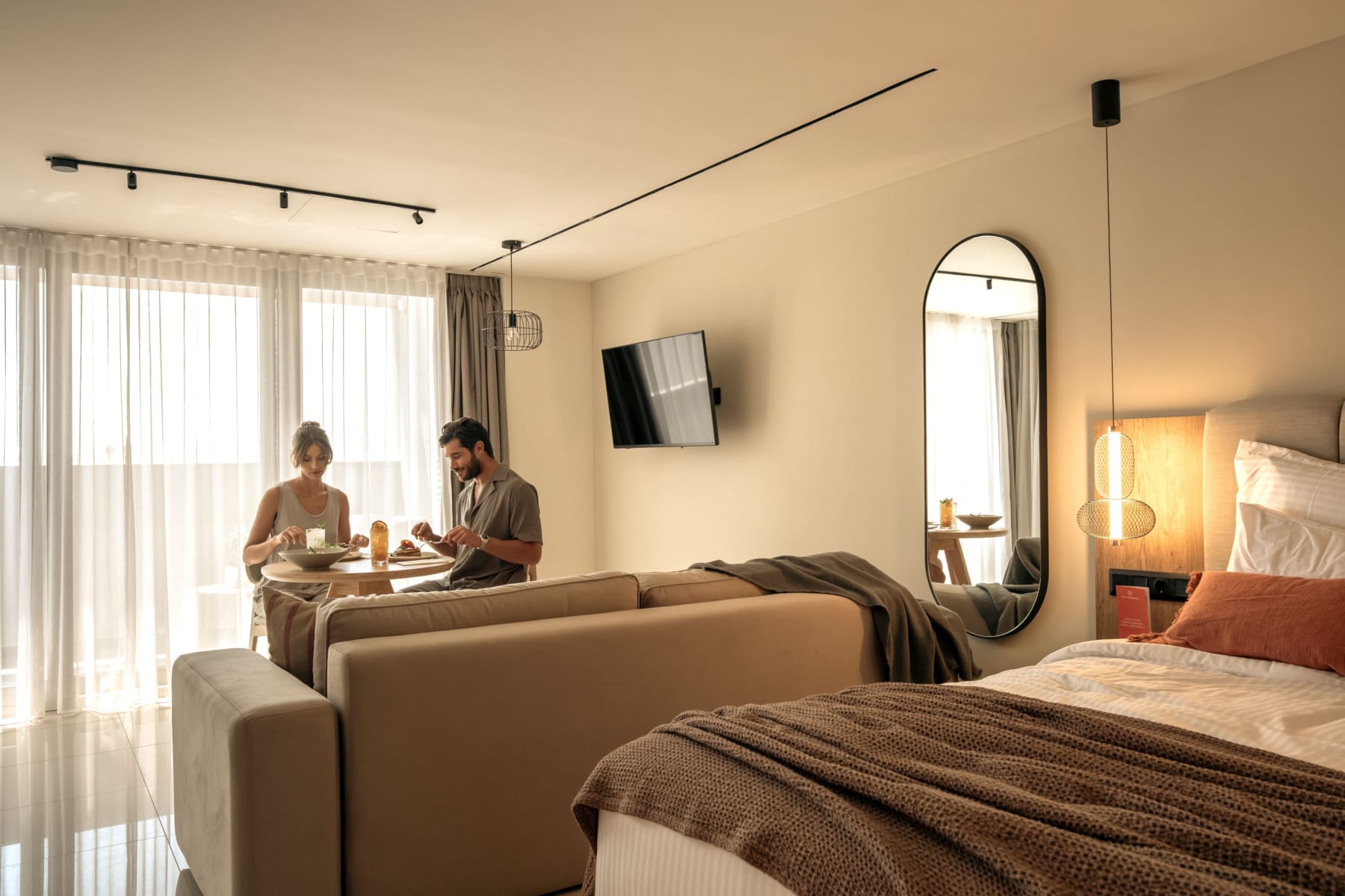a couple sitting at a table in a hotel room