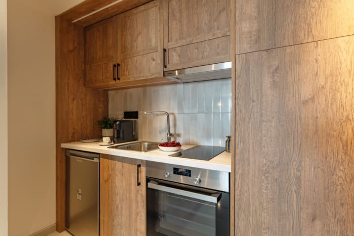 a kitchen with wood cabinets and stainless steel appliances