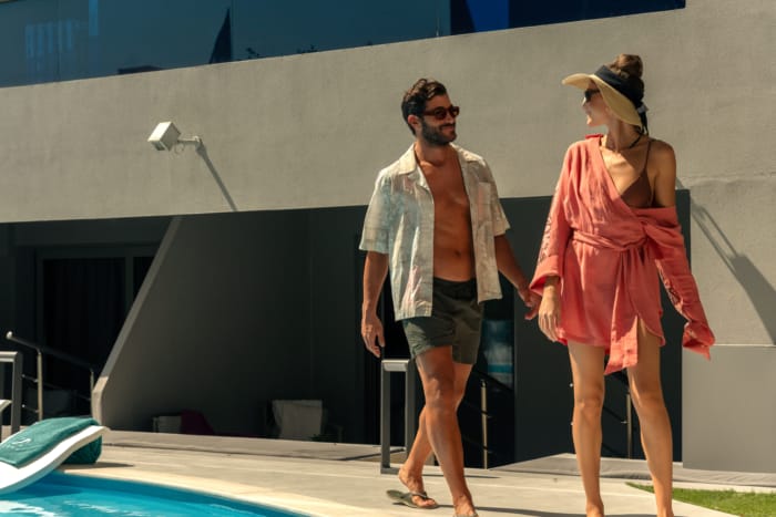 a person and person holding hands by a pool