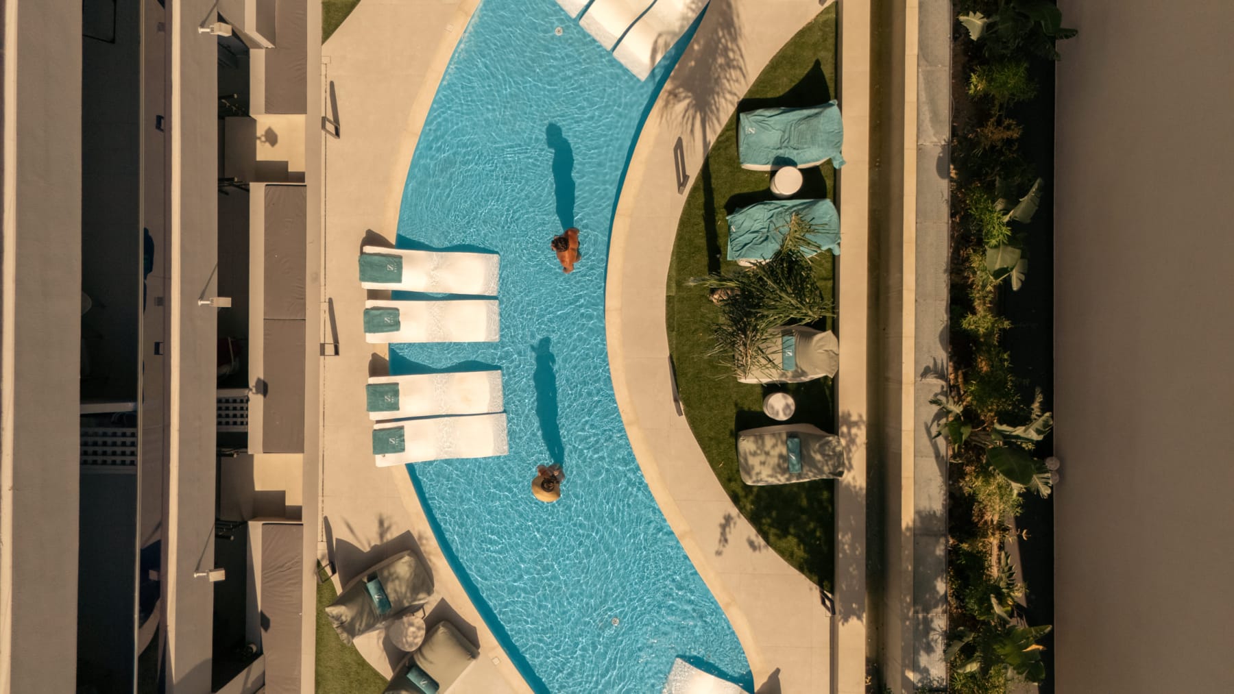 a pool with lounge chairs and a person in it