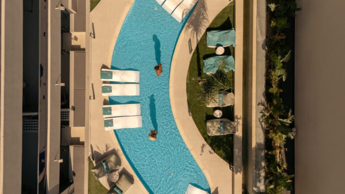 a pool with lounge chairs and a person in it