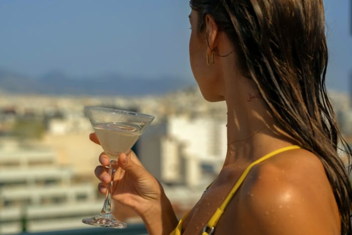 a person holding a glass of liquid