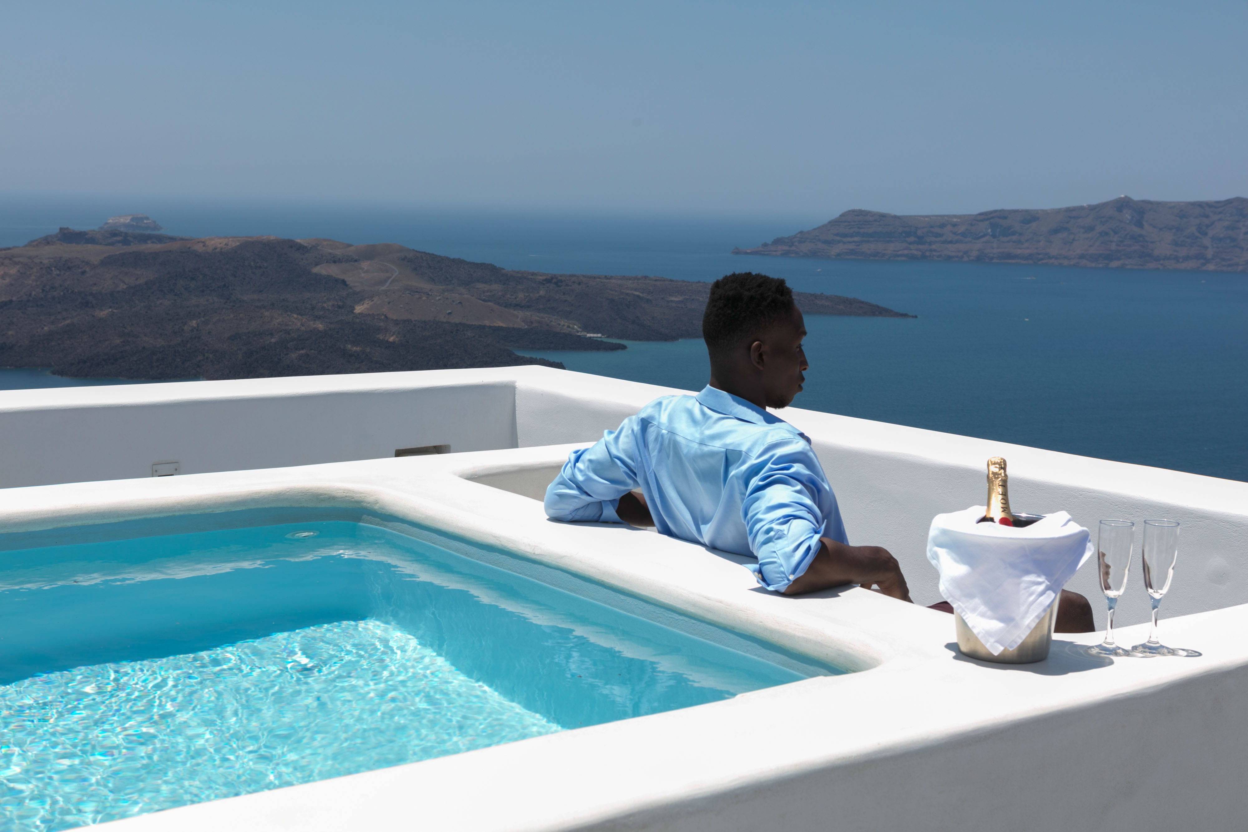 a person sitting in a pool overlooking the ocean