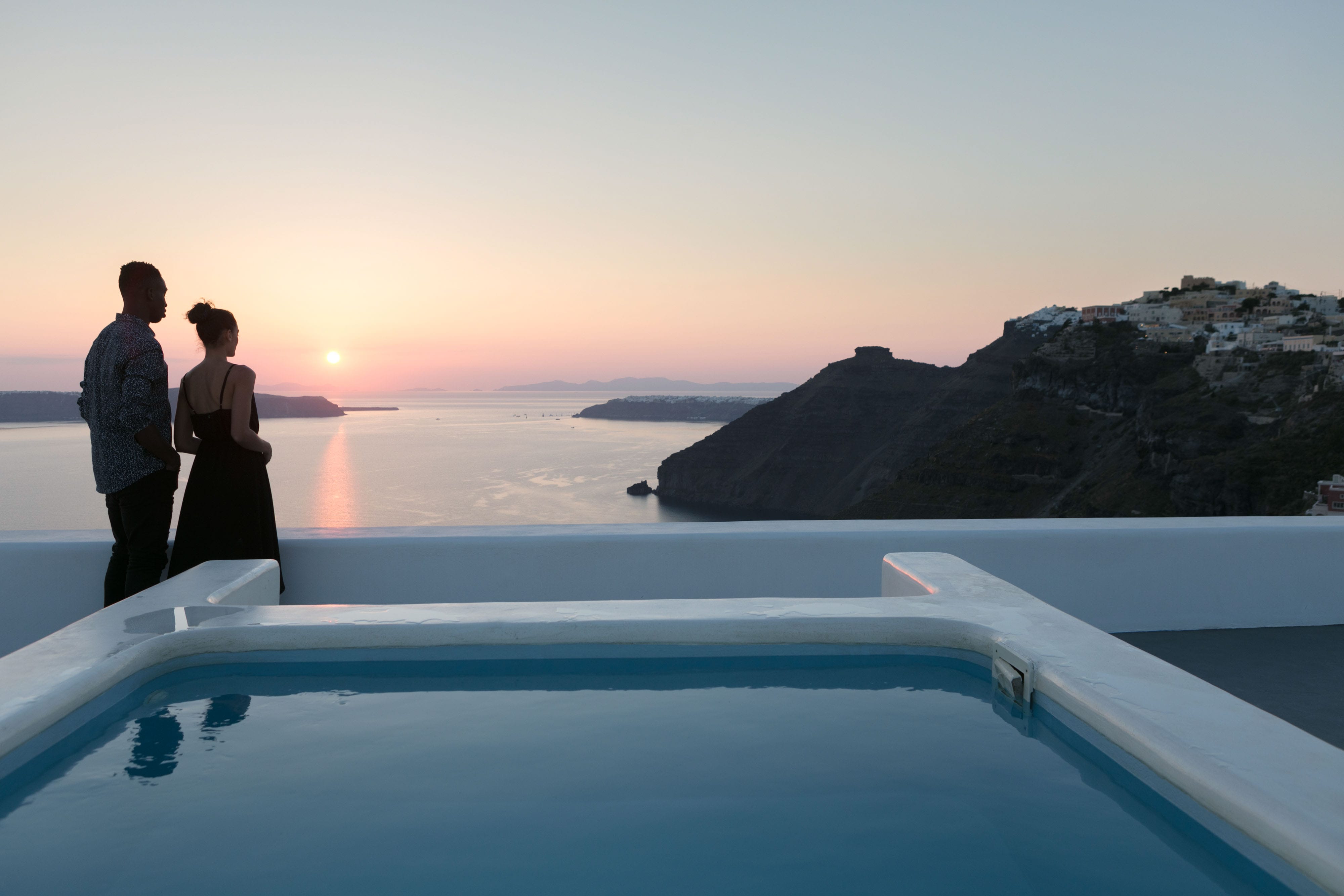 a person standing on a rooftop overlooking a body of water